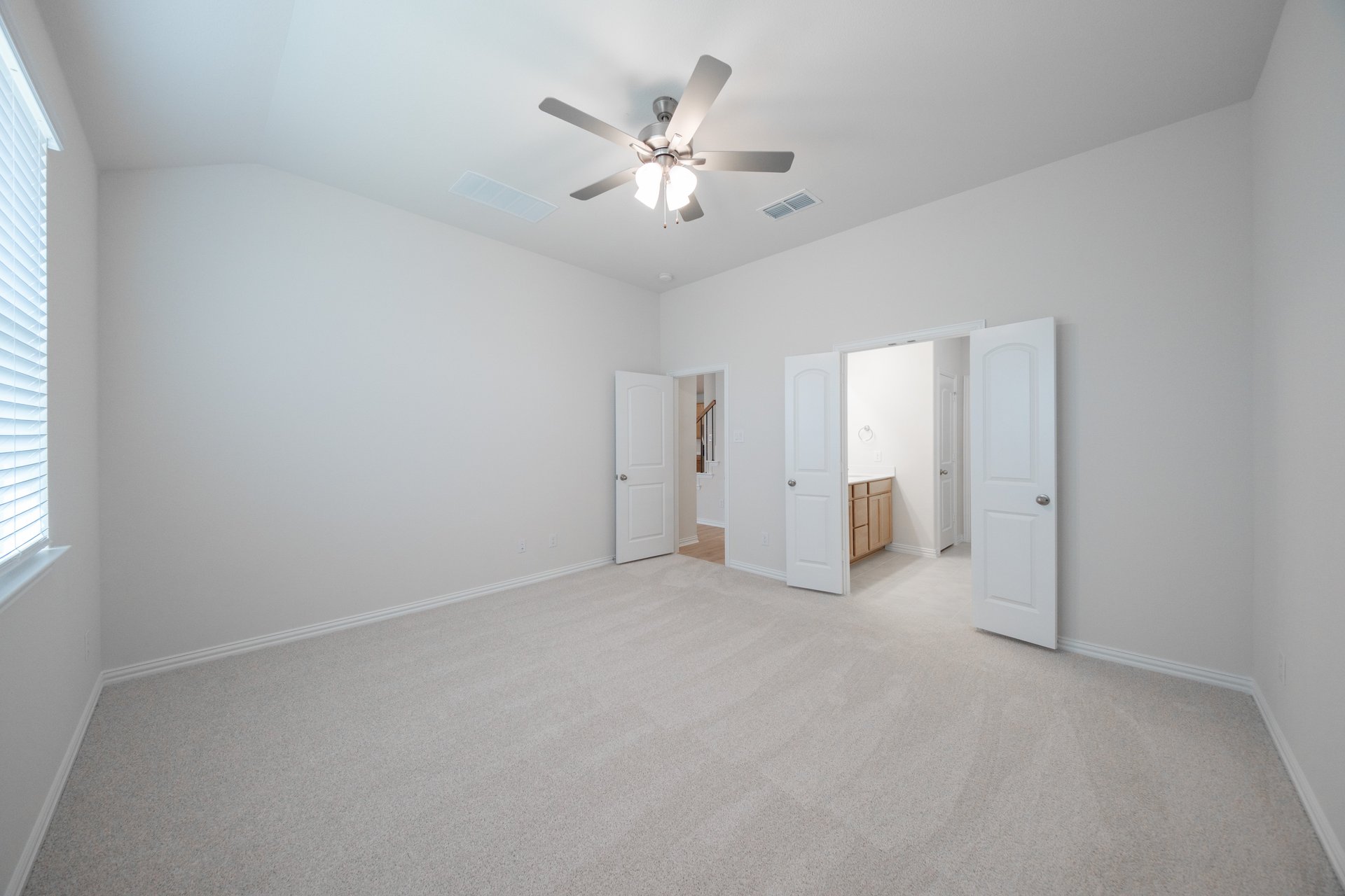 primary bedroom with carpet and ceiling fan