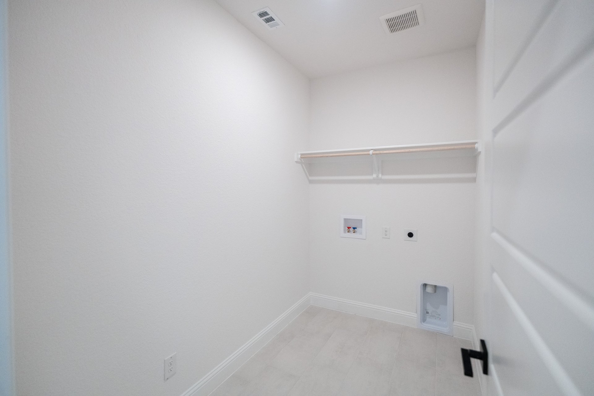 laundry room with tile floors and white shelf