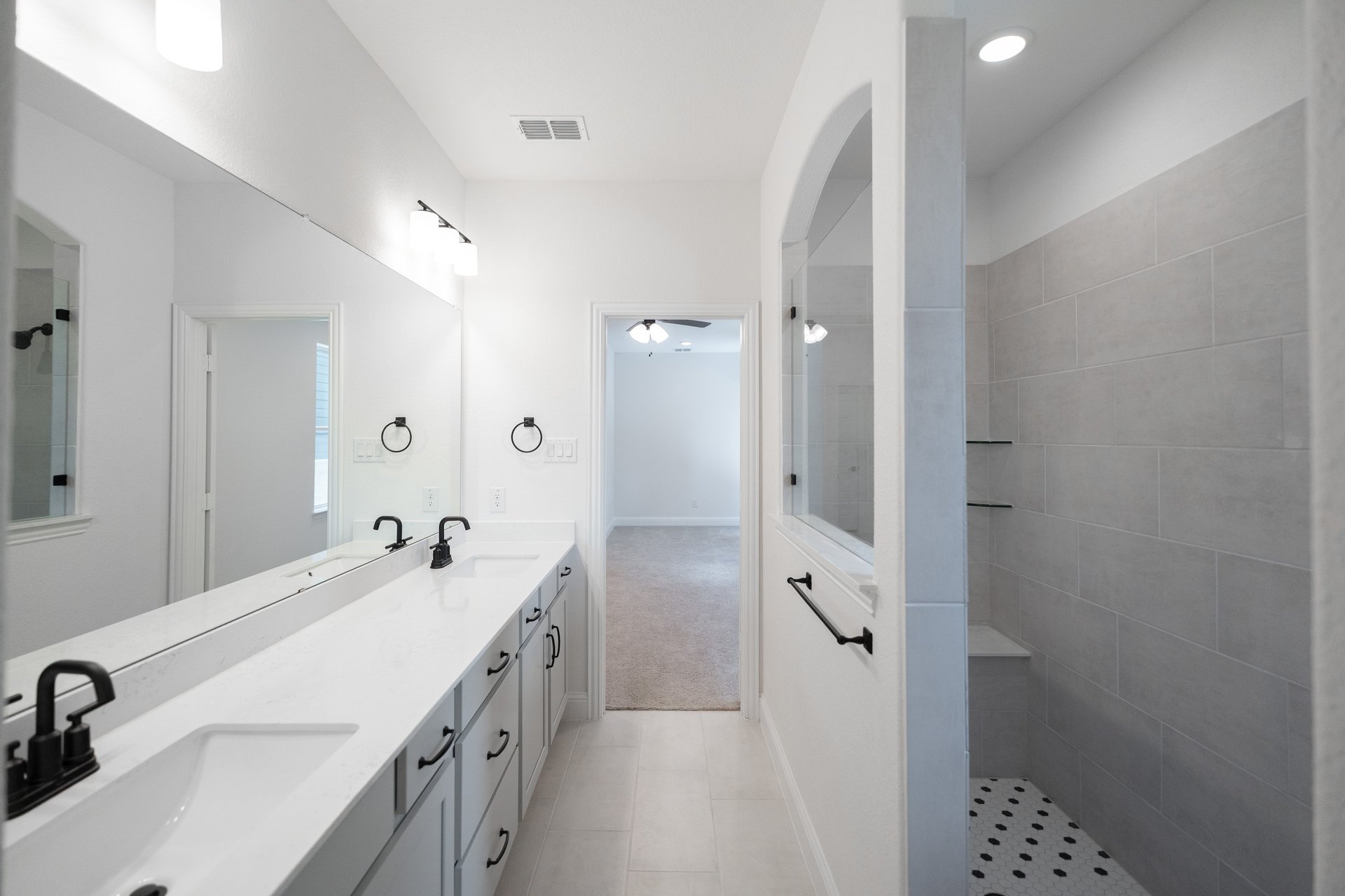 primary bathroom with walk-in shower and cabinets