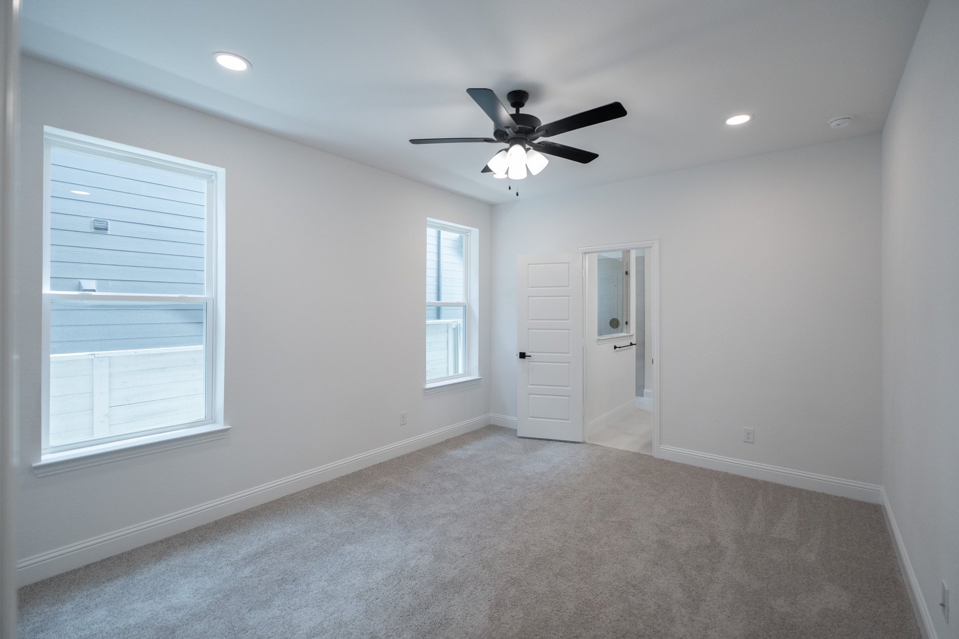 primary bedroom with carpet and ceiling fan