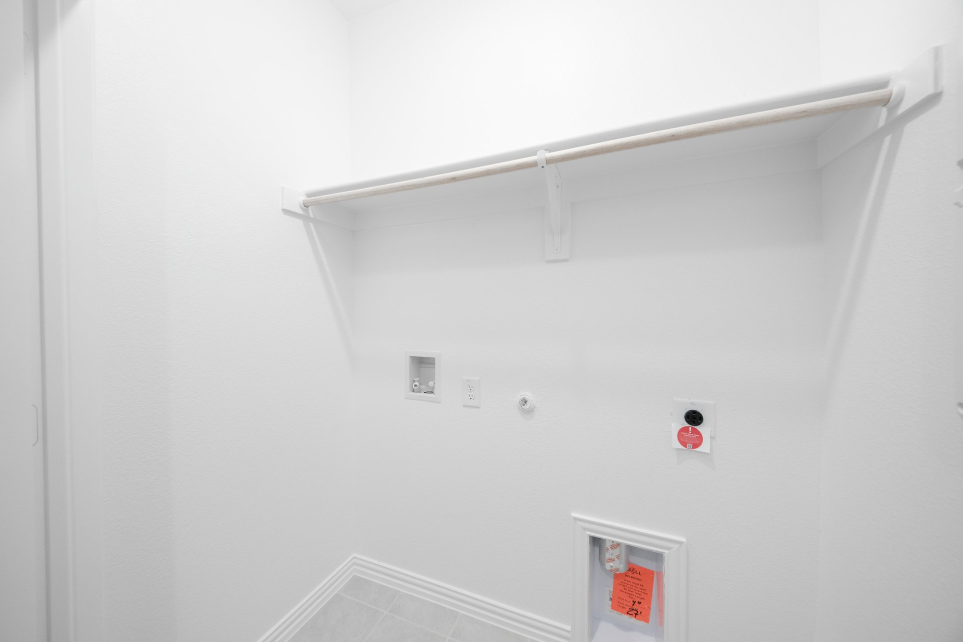 laundry room with tile floors and white shelf
