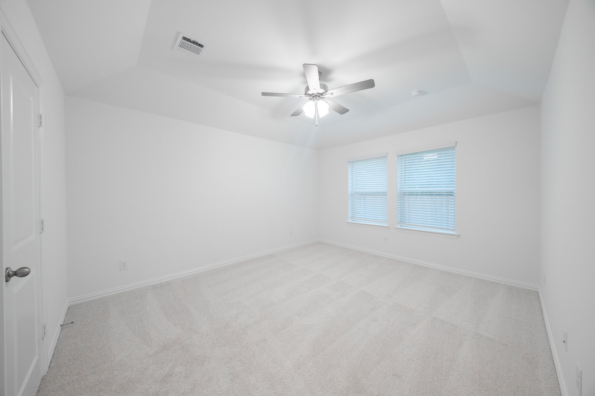 primary bedroom with carpet and ceiling fan