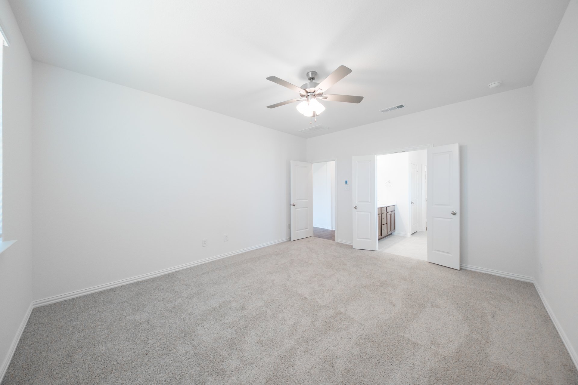 primary bedroom with carpet and ceiling fan