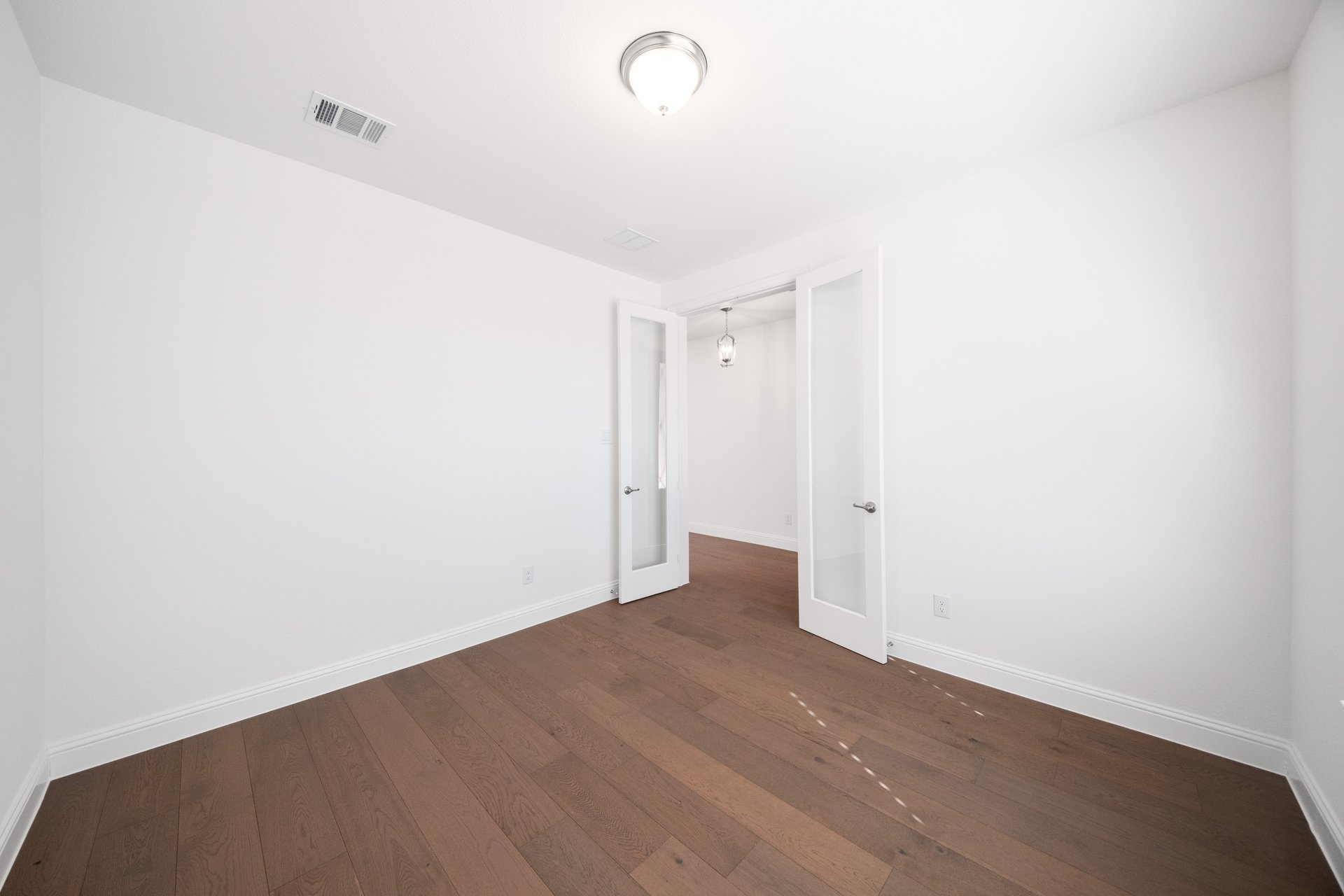 study with wood flooring and french doors 