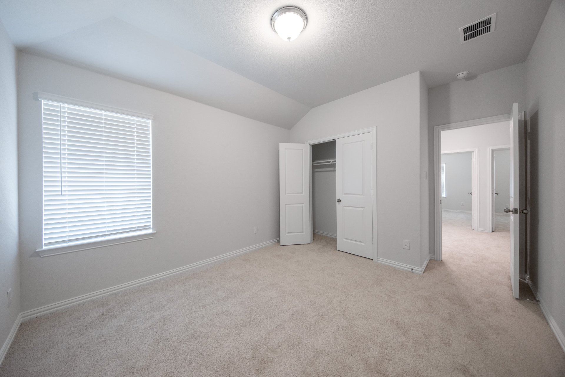 guest bedroom with carpet and window