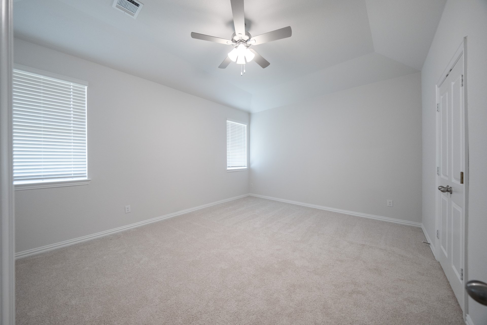 primary bedroom with carpet and windows