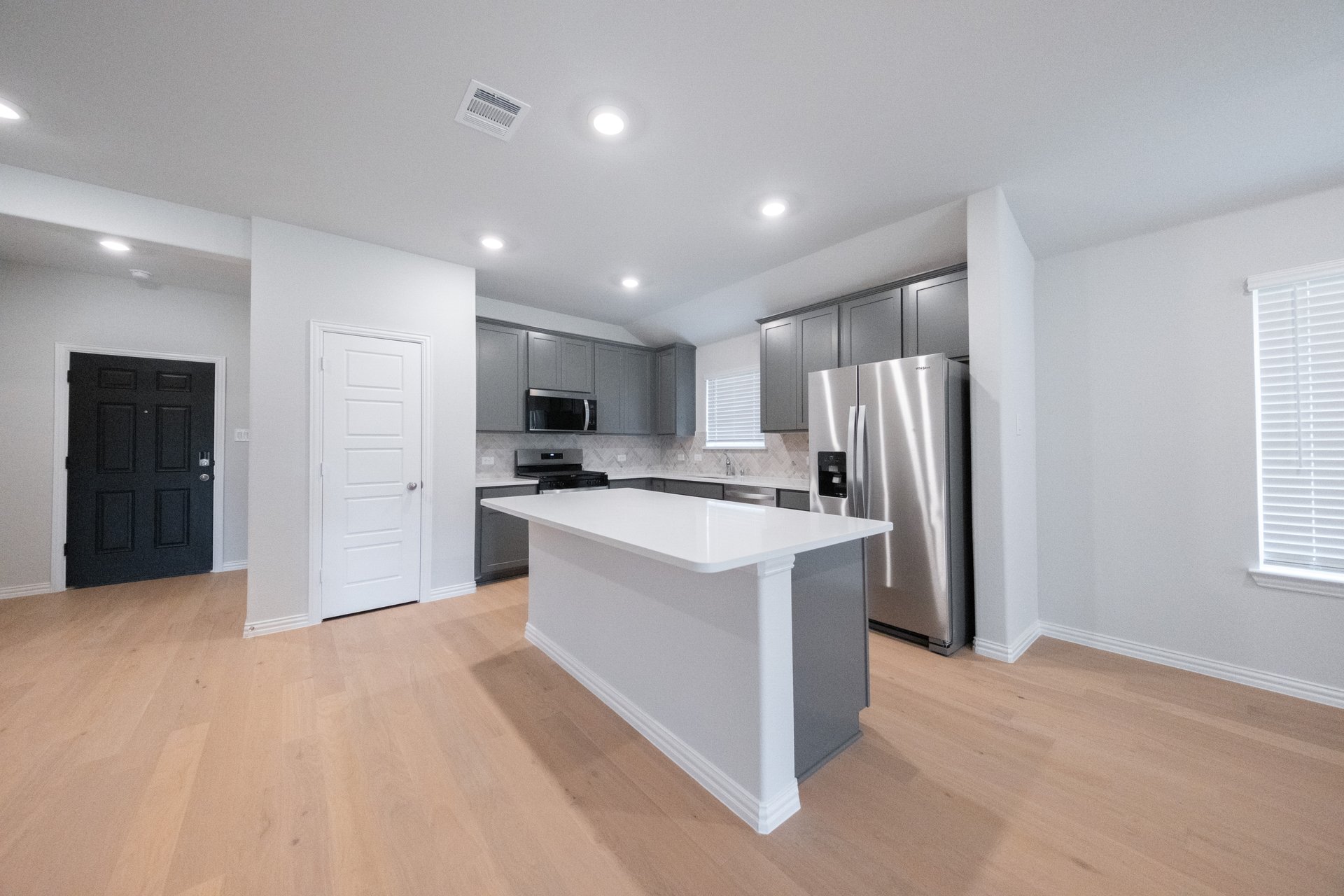 open kitchen with wood floors and gray cabinets