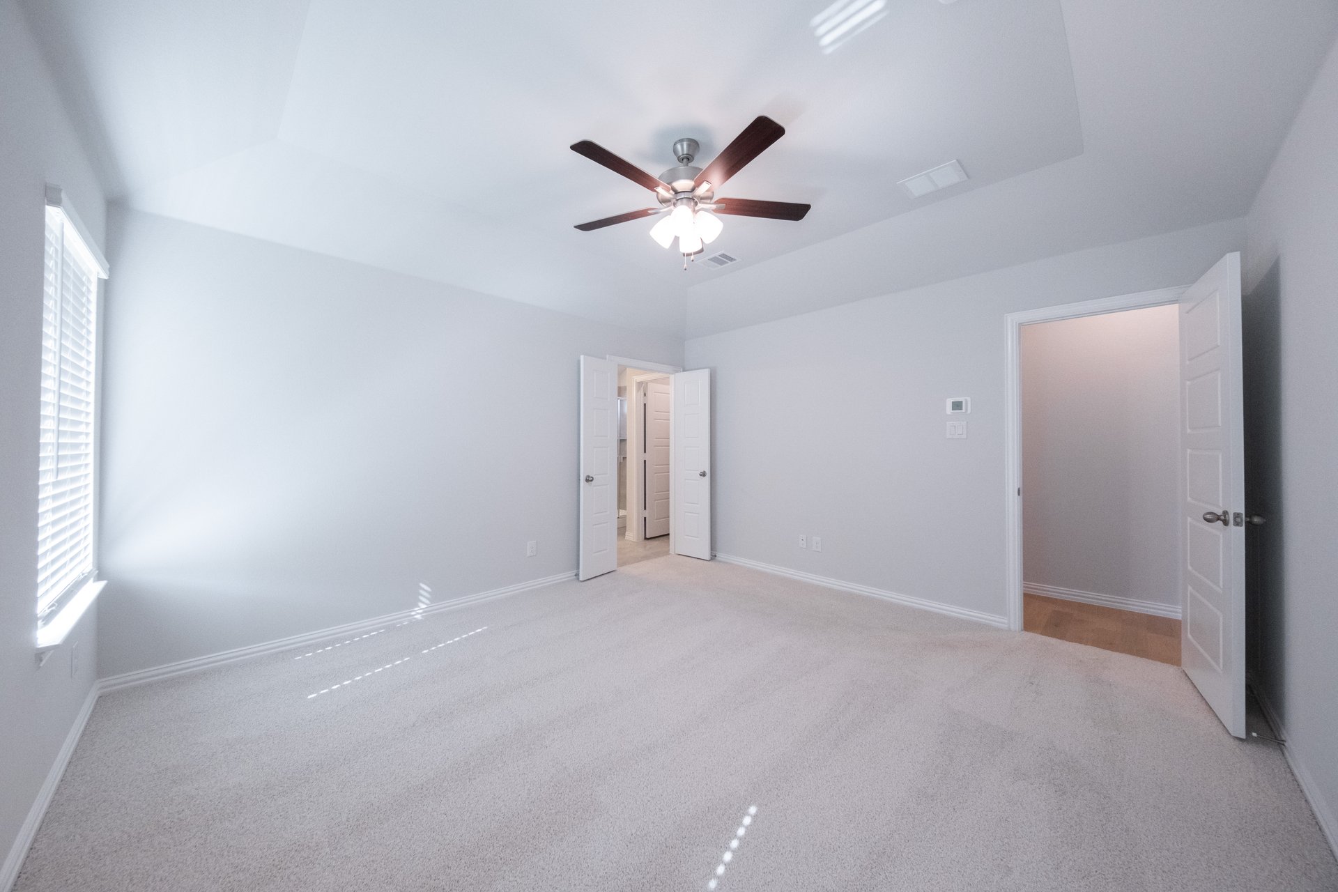 primary bedroom with carpet and ceiling fan