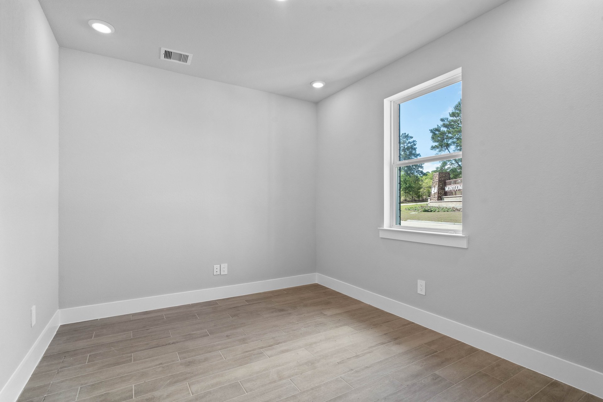 spacious study with hardwood flooring and windows