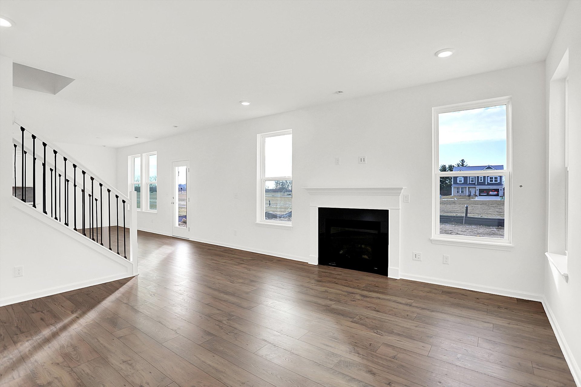 great room with plank flooring and fireplace