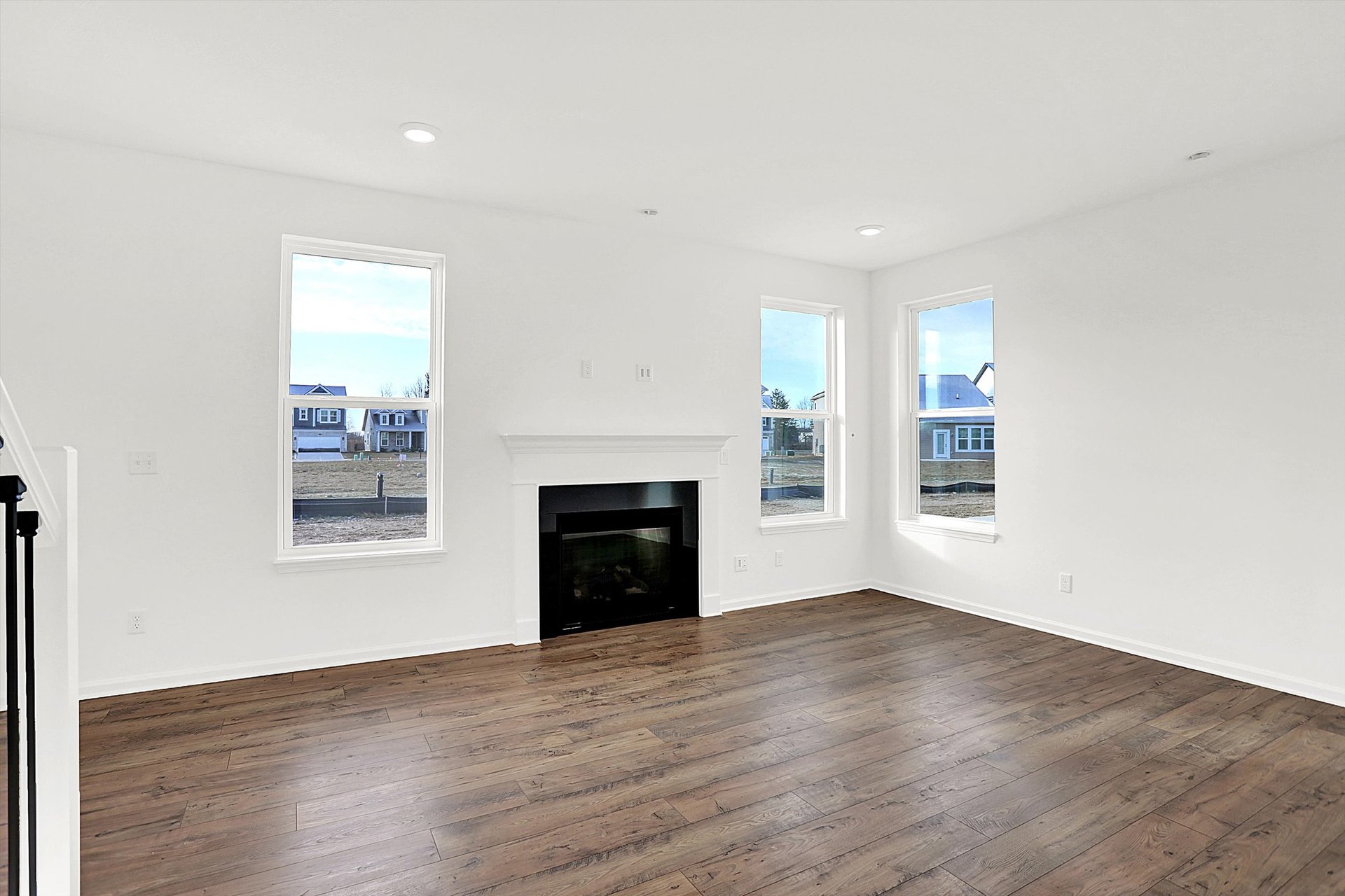 great room with plank flooring and fireplace