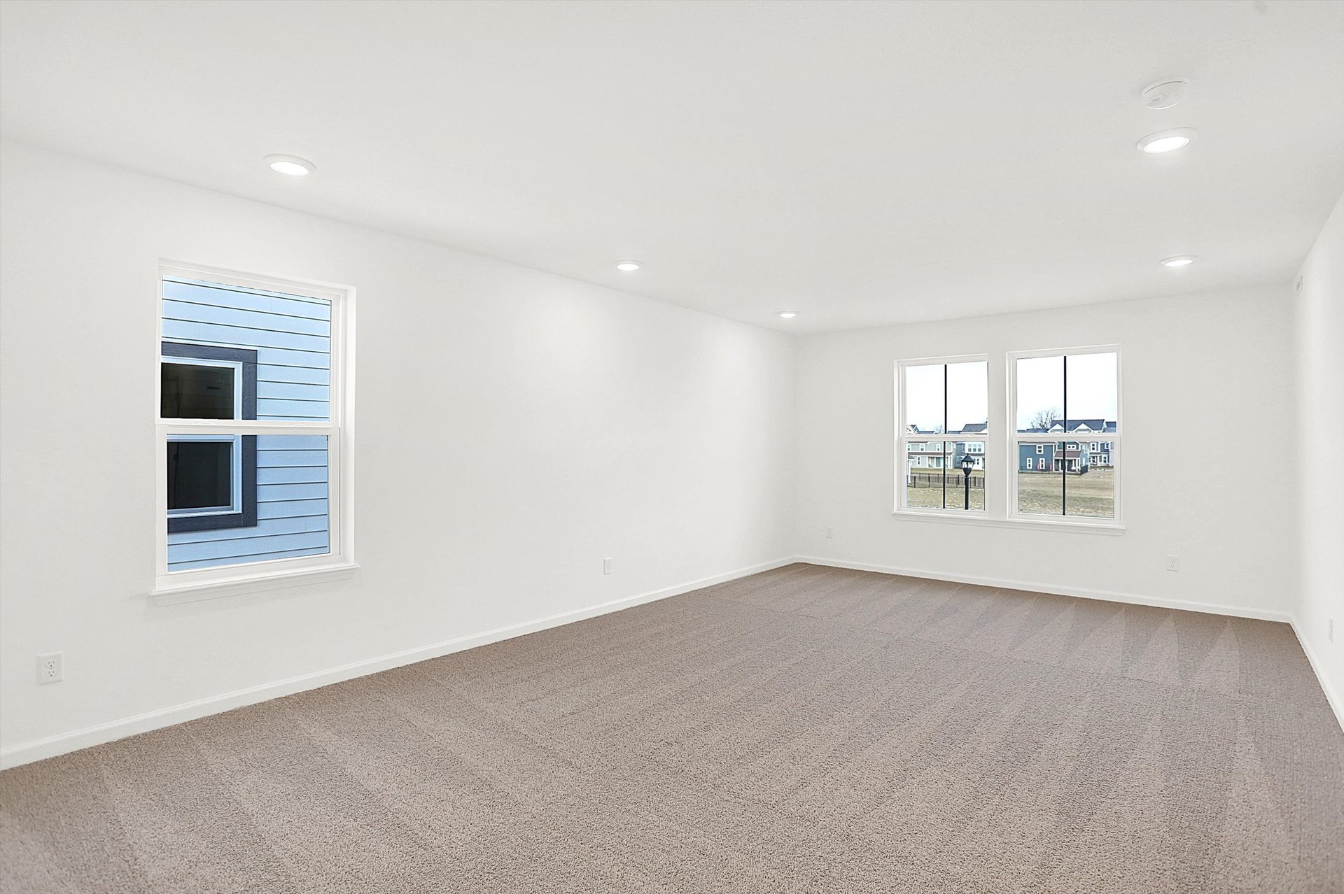 bonus room with tan carpet and white walls