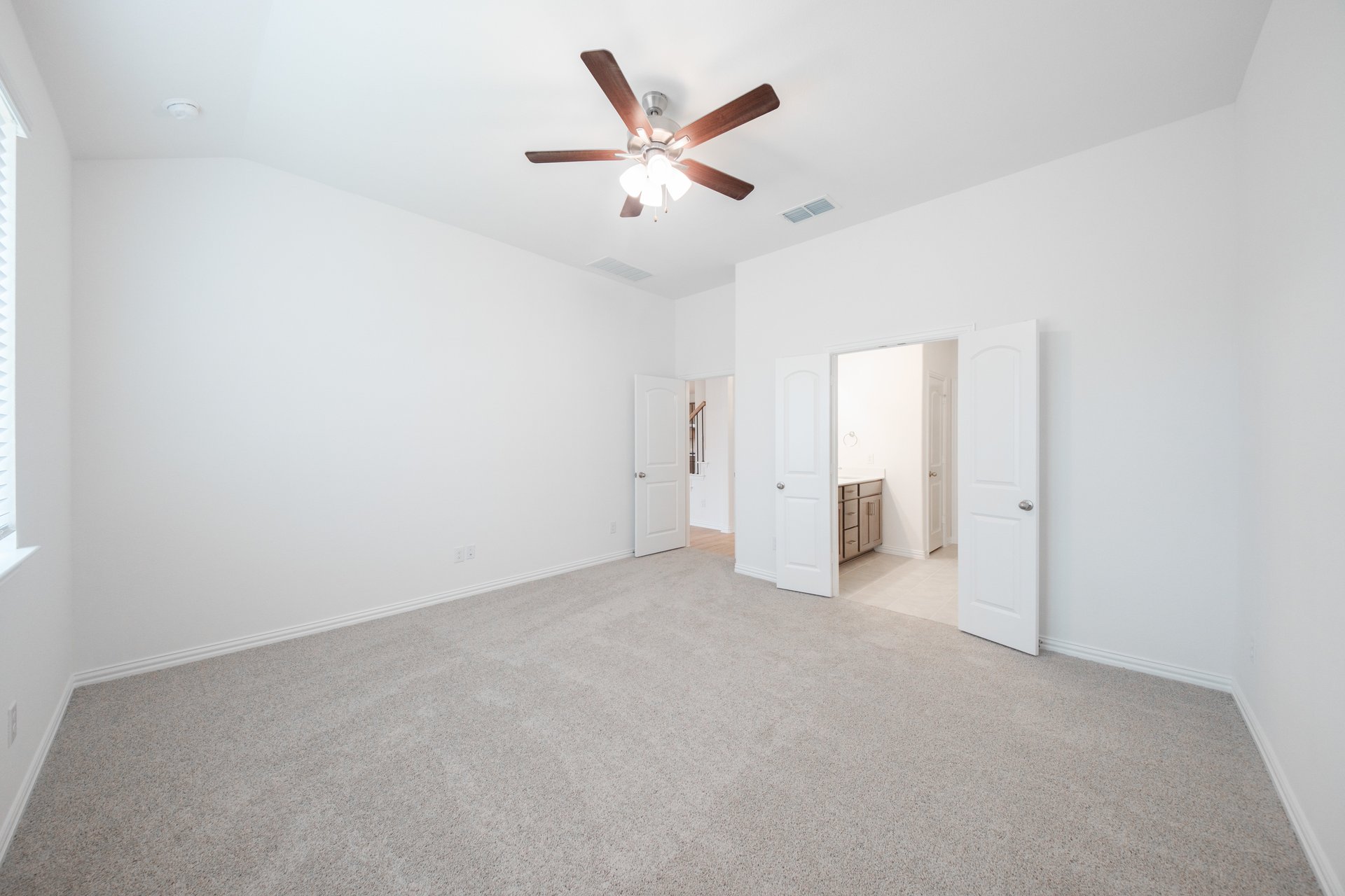 primary bedroom with carpet and ceiling fan