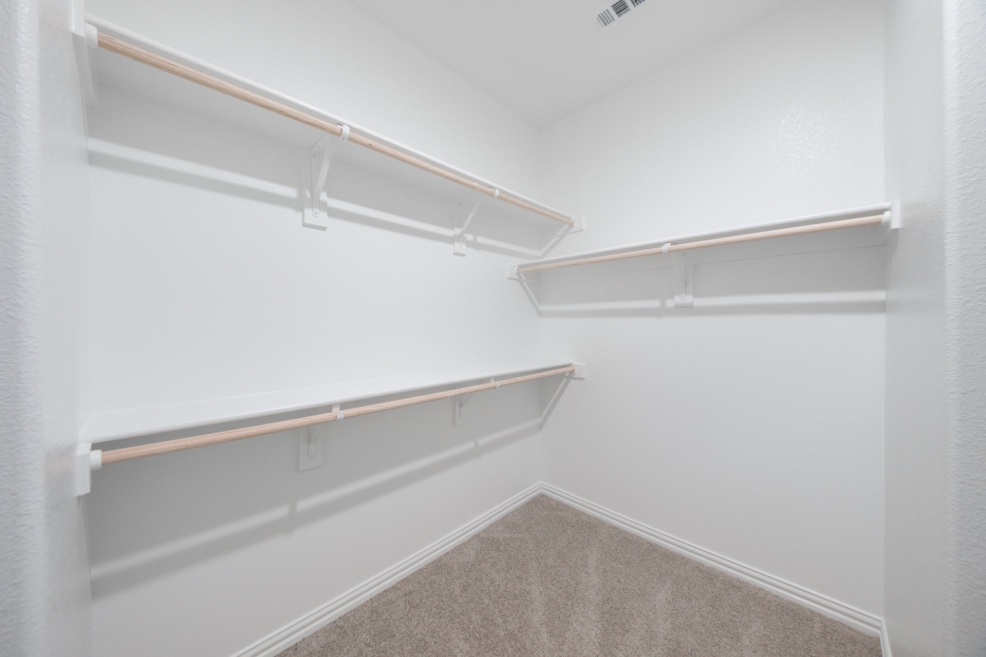primary bedroom closet with carpet and white shelves