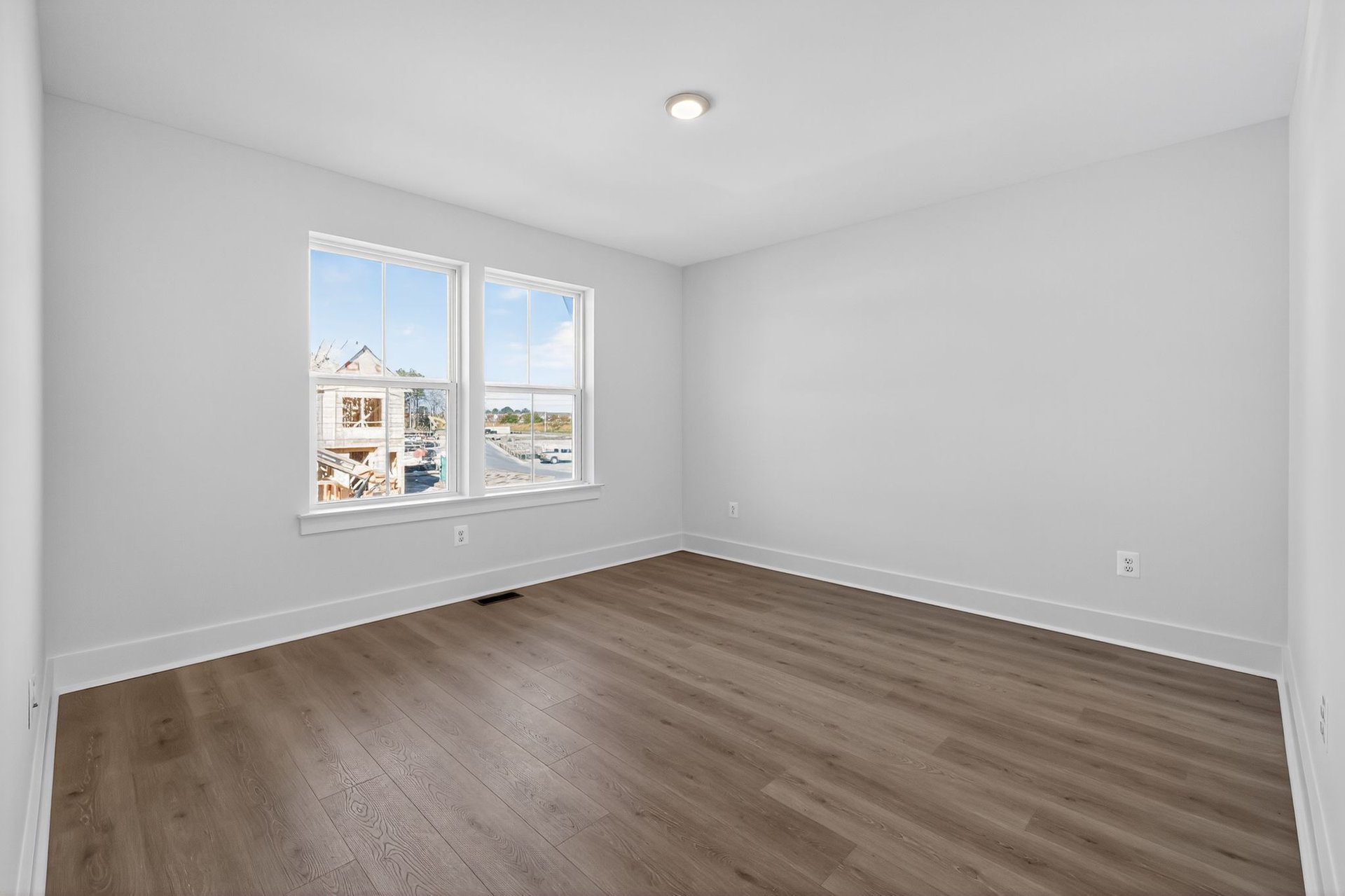 spacious primary suite with windows and designer floors