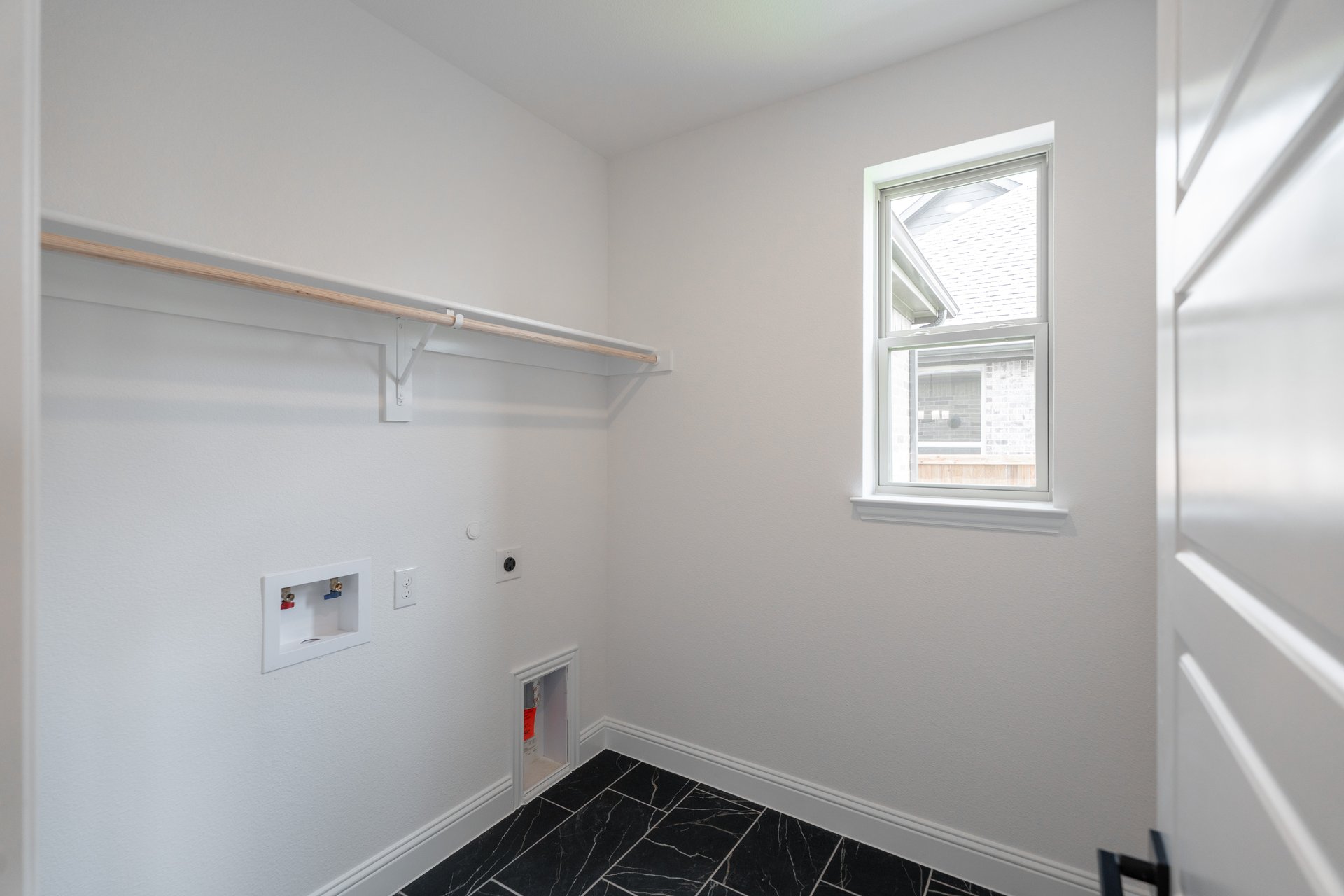 laundry room with tile floors and white shelf