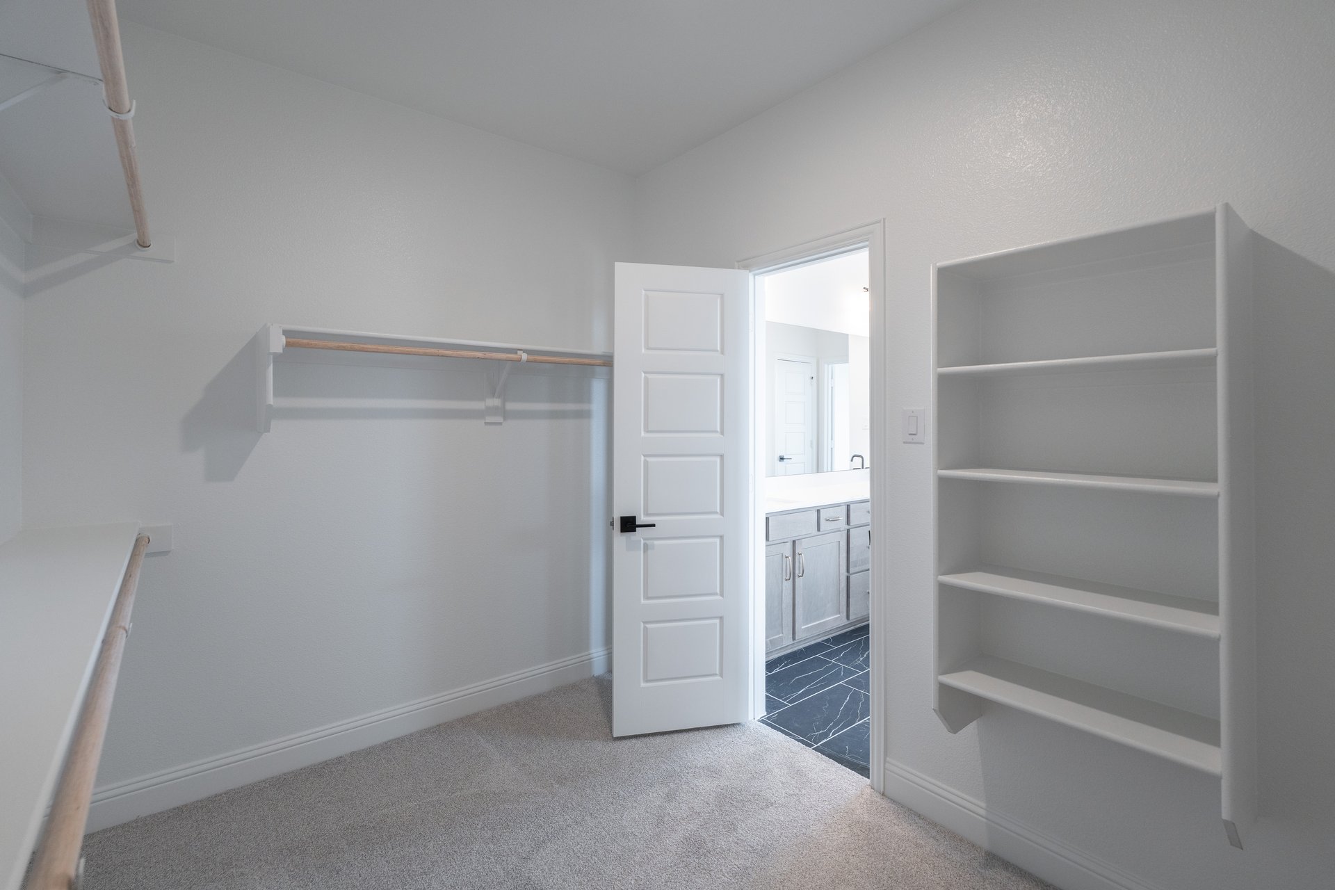  primary bedroom closet with carpet and white shelves