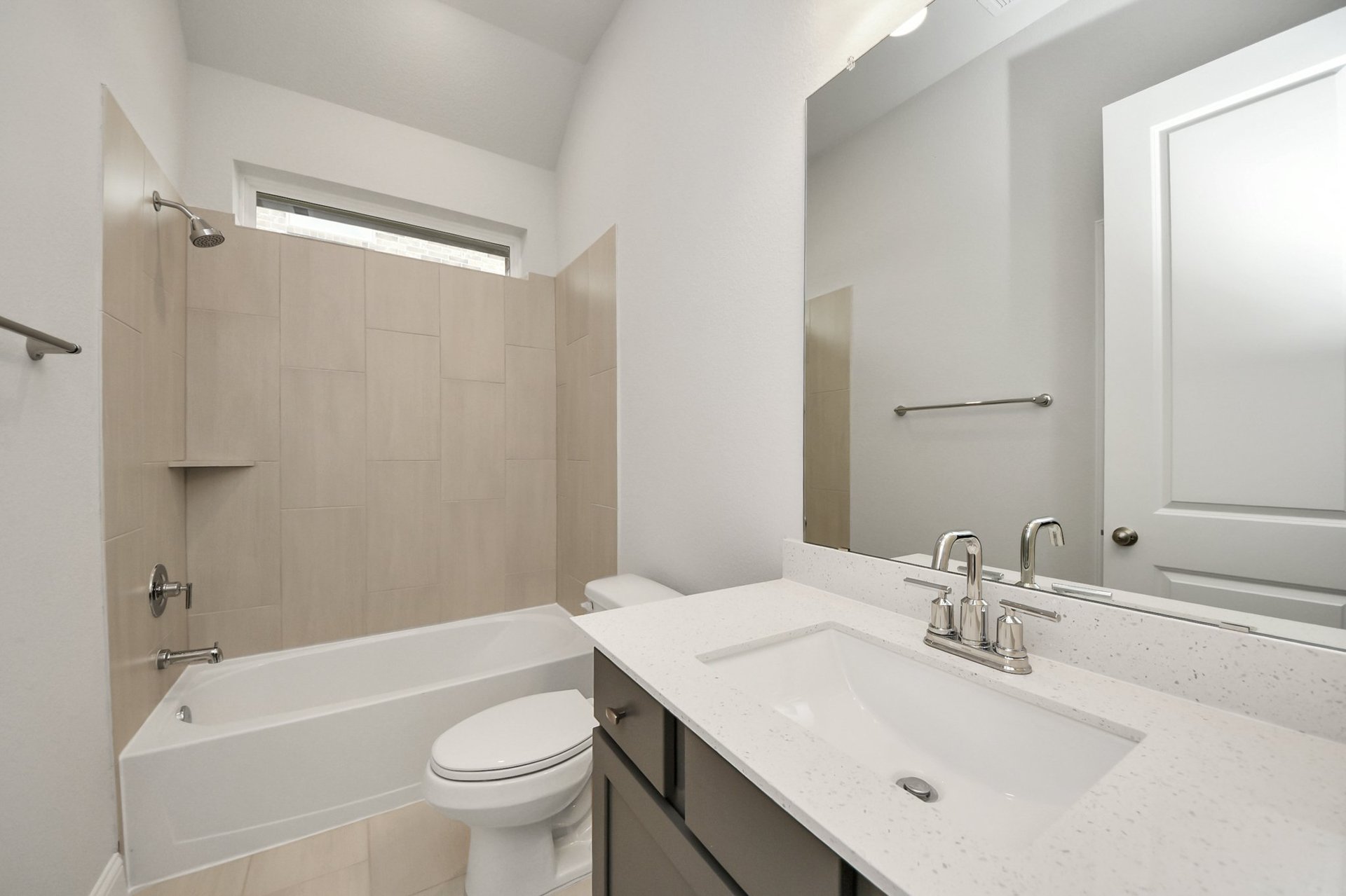 tiled shower and dark cabinetry