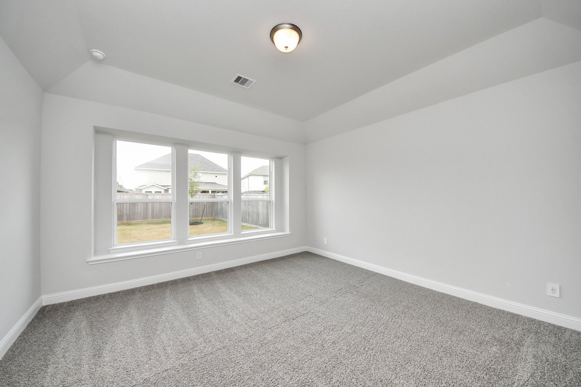 large bedroom with carpet and tall ceilings