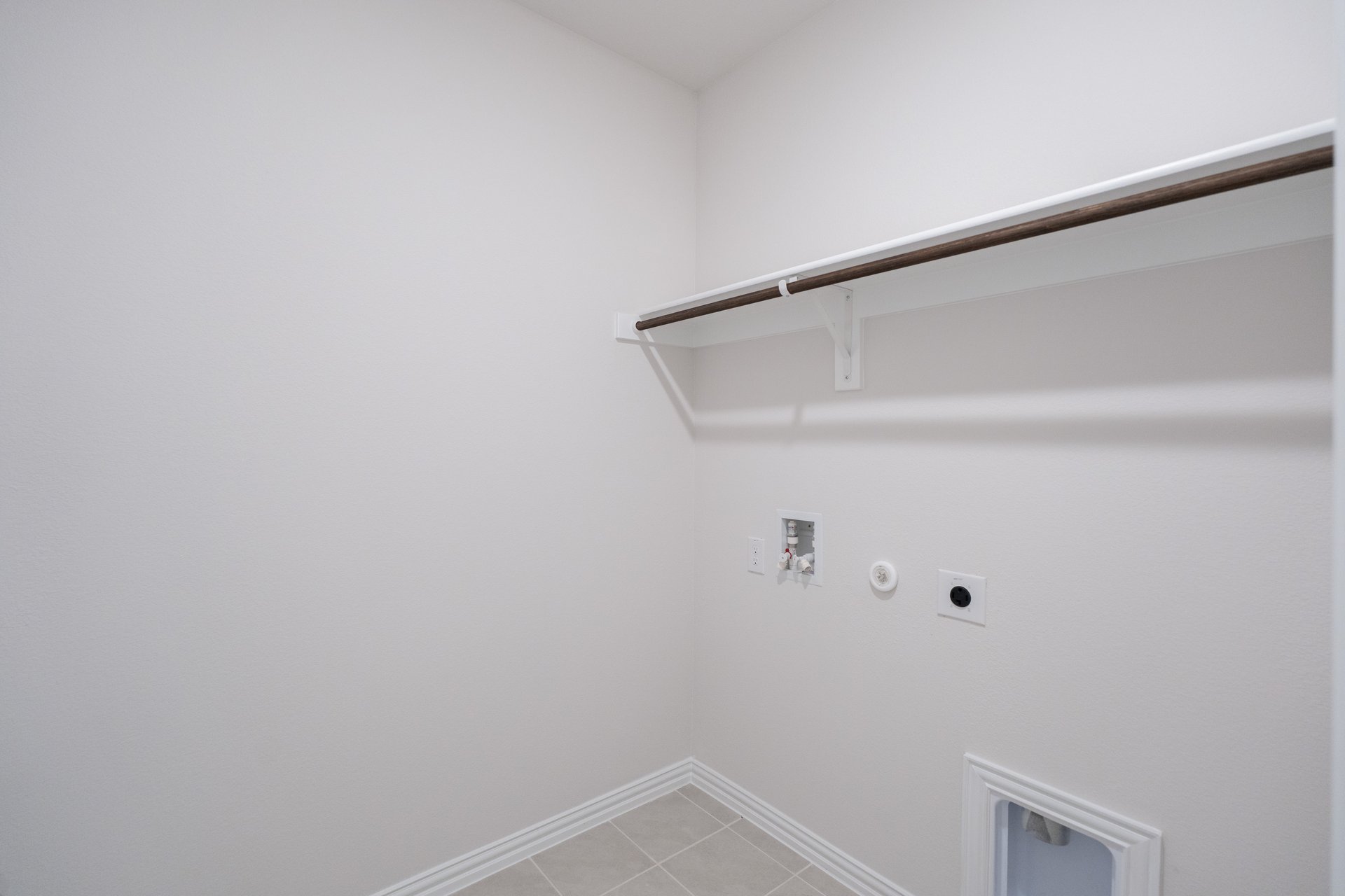 laundry room with tile floors and white shelf