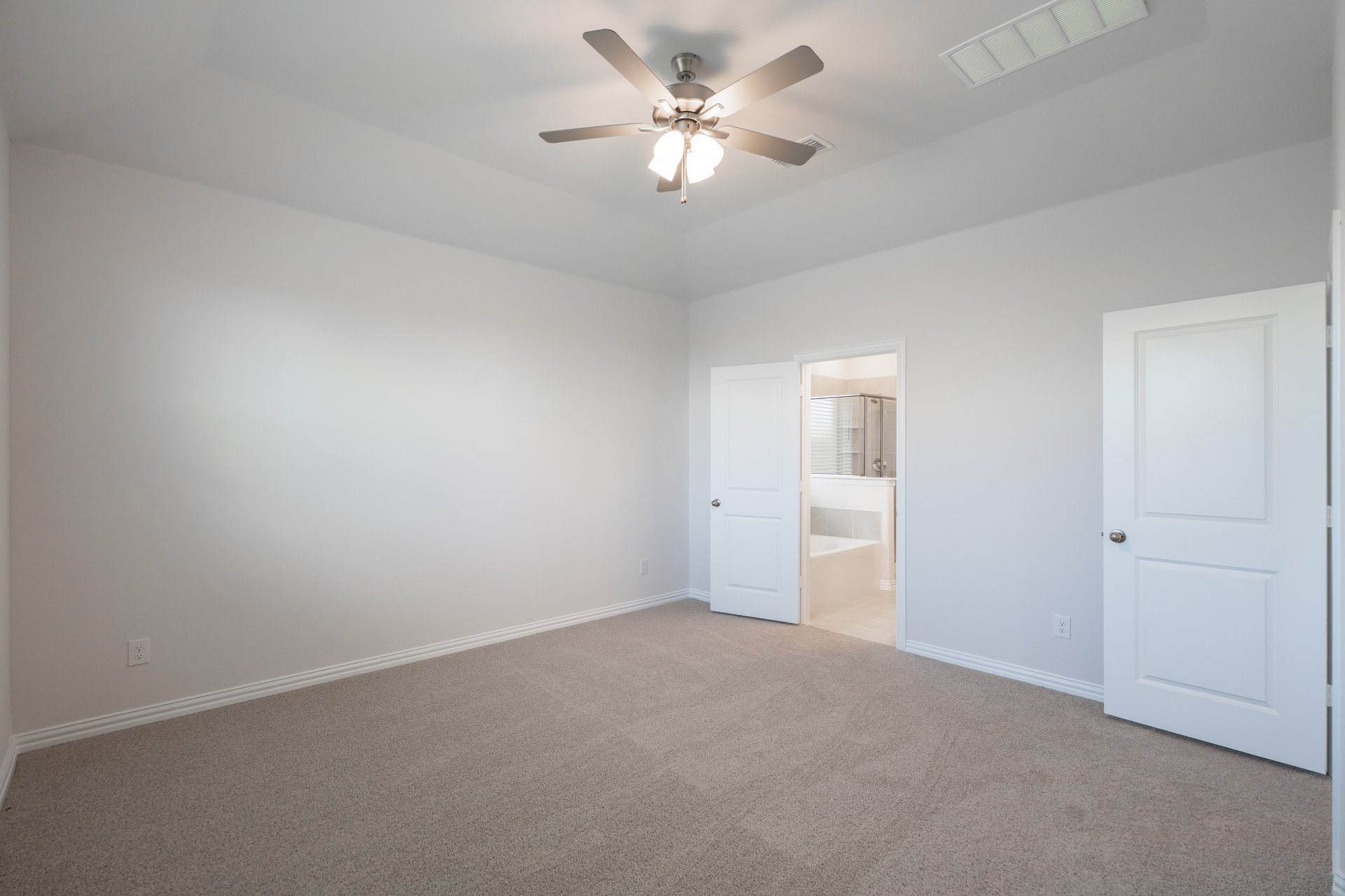 primary bedroom with carpet and ceiling fan