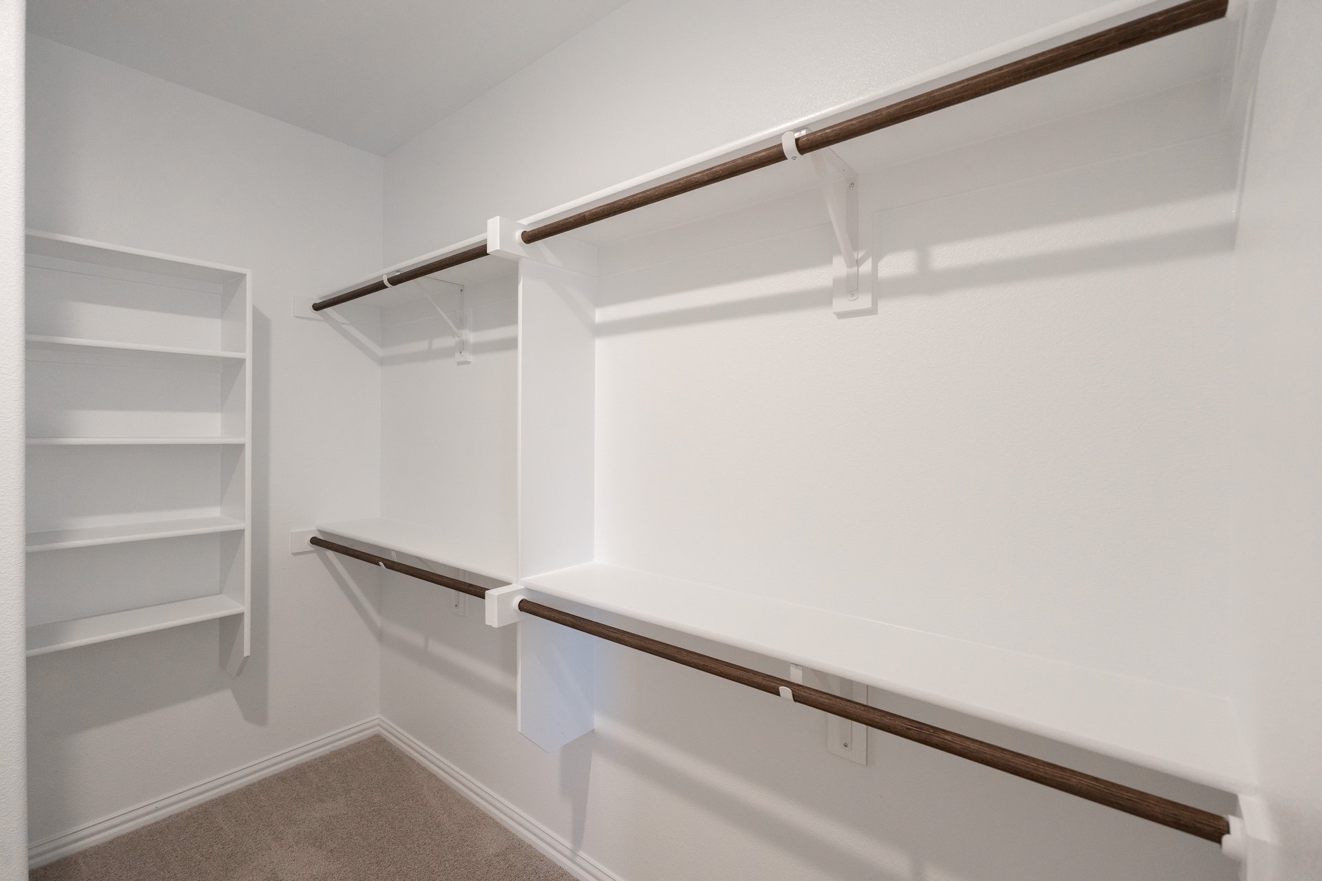 primary bedroom closet with carpet and white shelves