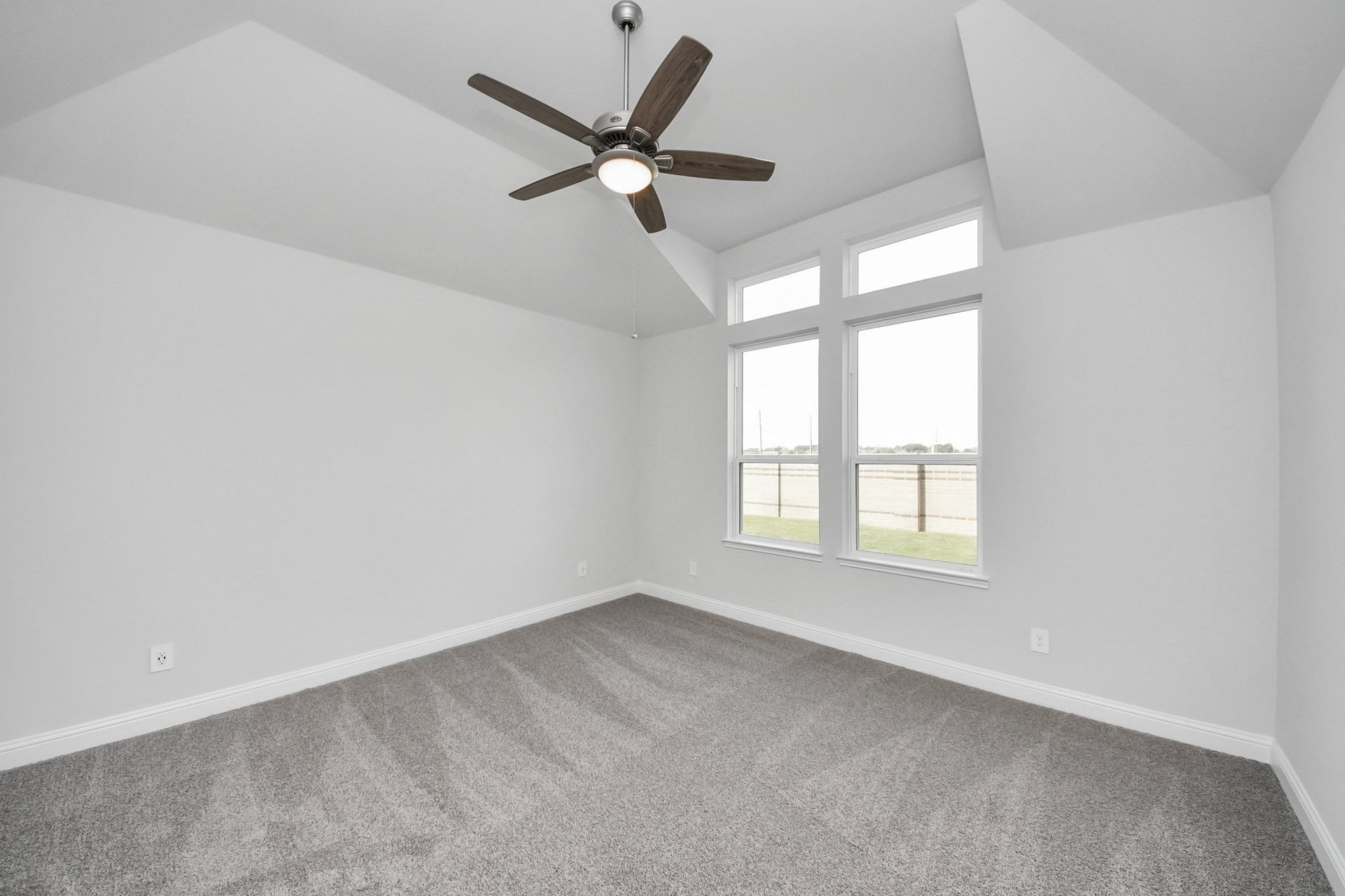 high ceilings with fan and carpeted flooring