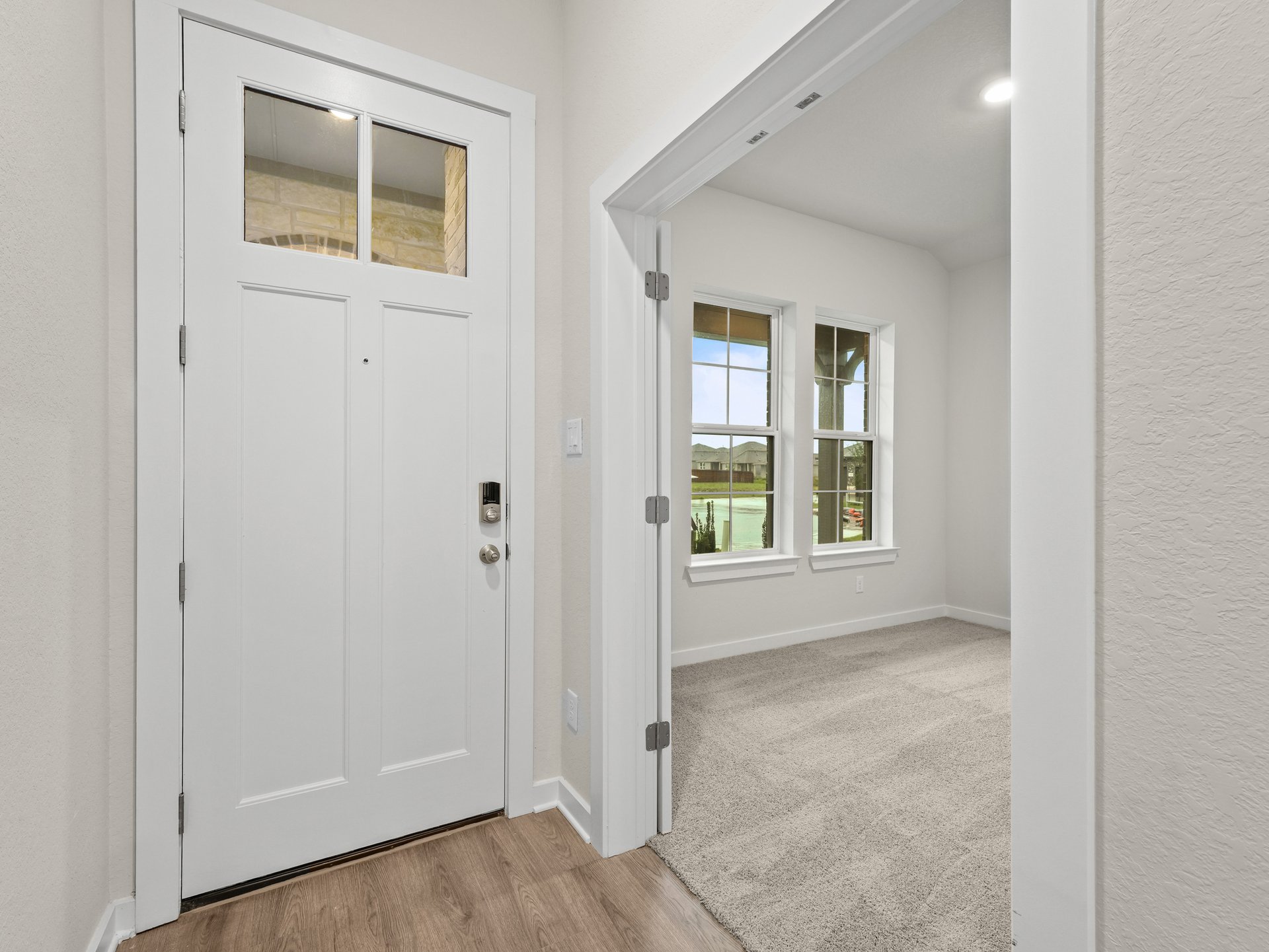 foyer with door, brown flooring and entrance to the study