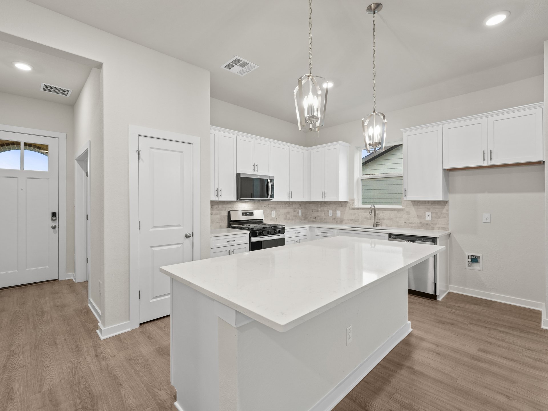 kitchen with white cabinets, brown flooring, pendant lighting and quartz countertops