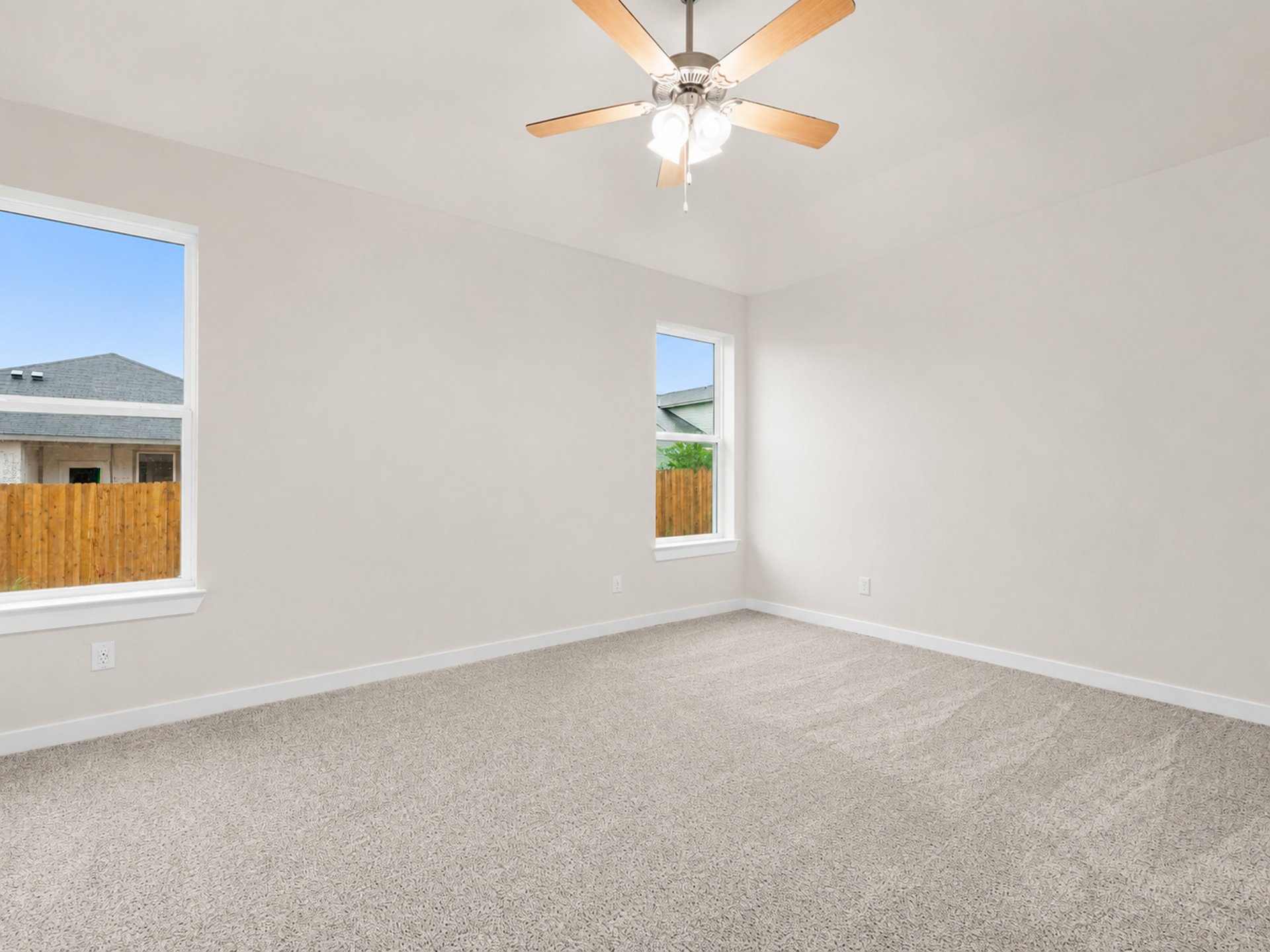 Primary bedroom with carpet, windows and ceiling fan