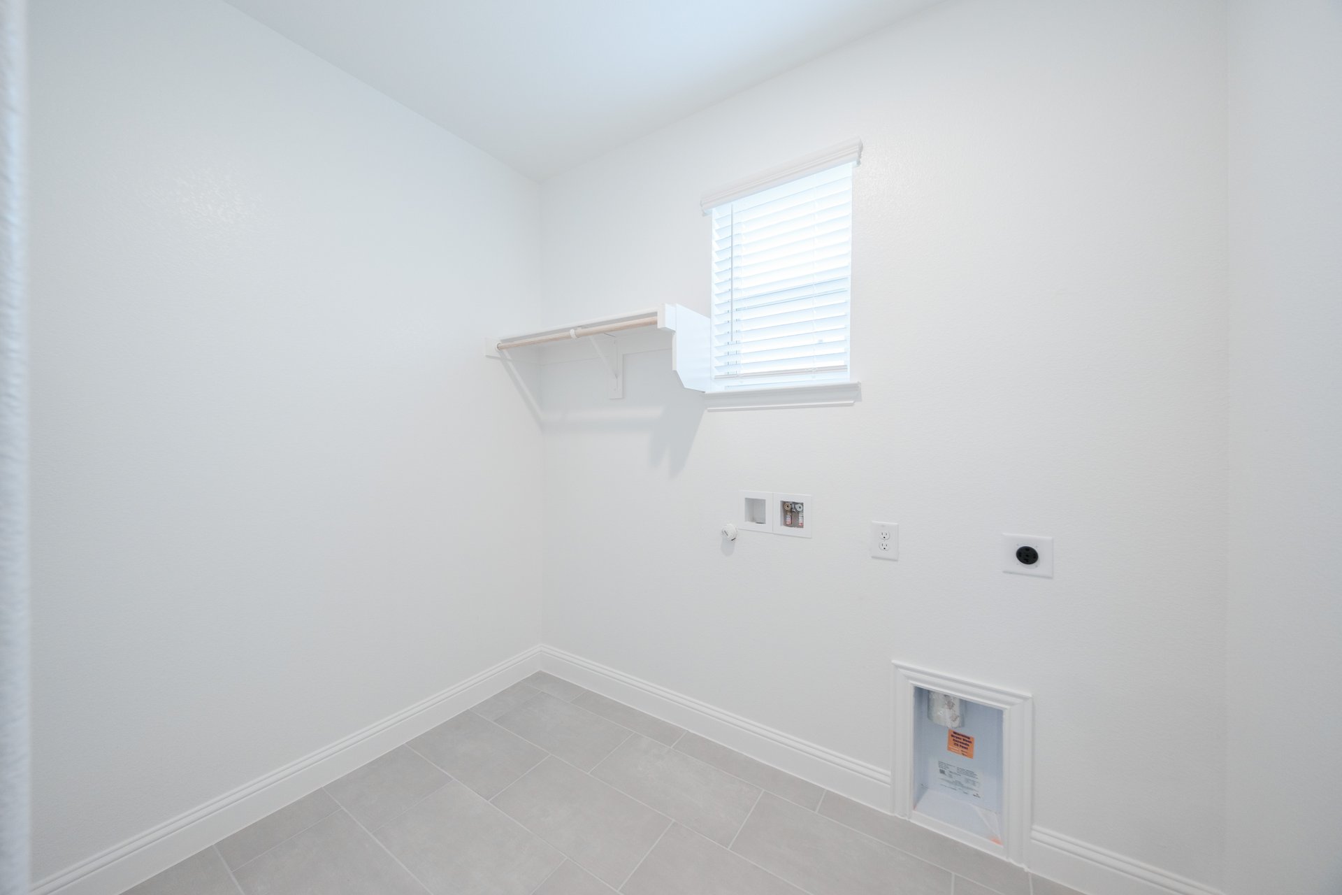 laundry room with tile floors and white shelf