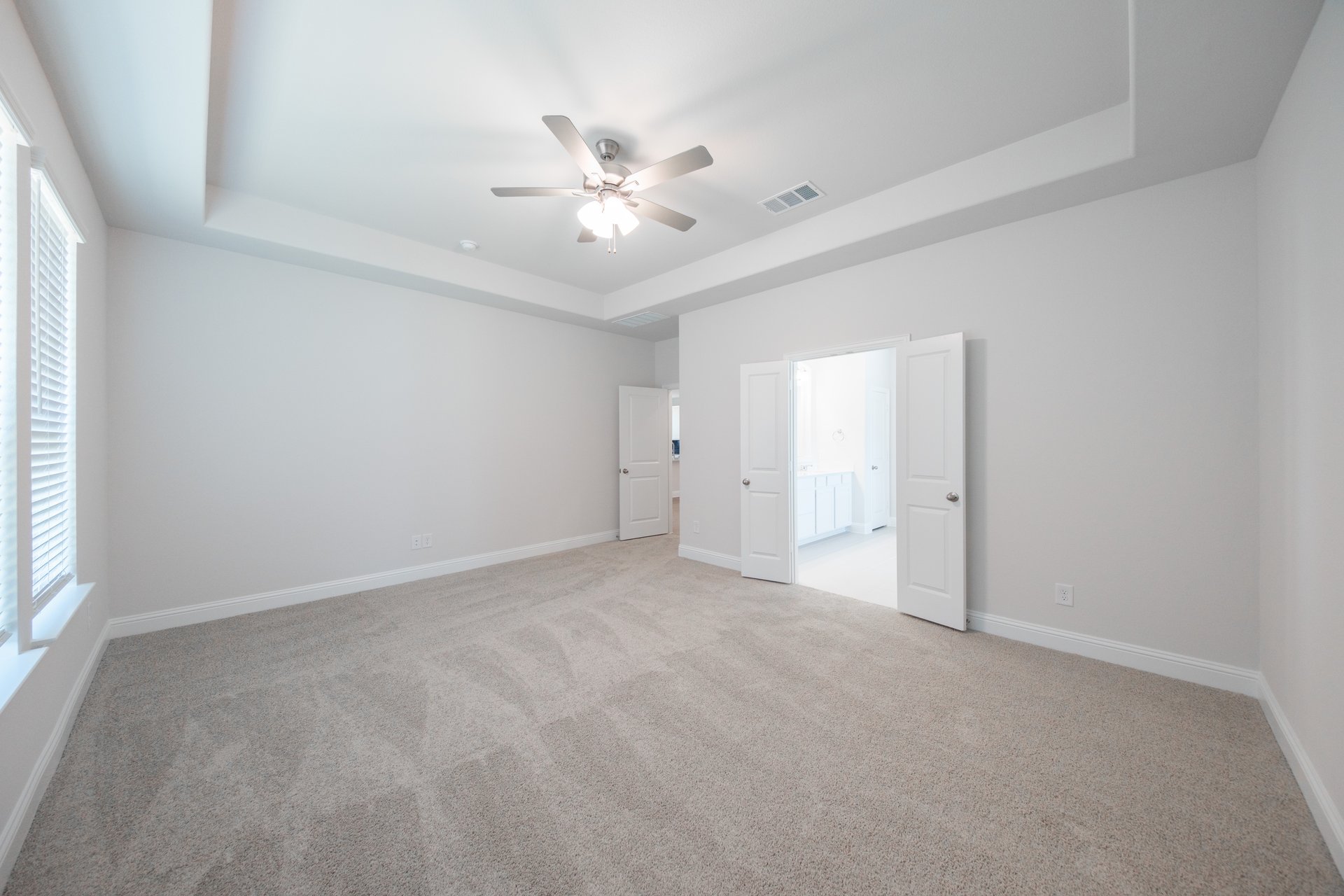 primary bedroom with carpet and ceiling fan