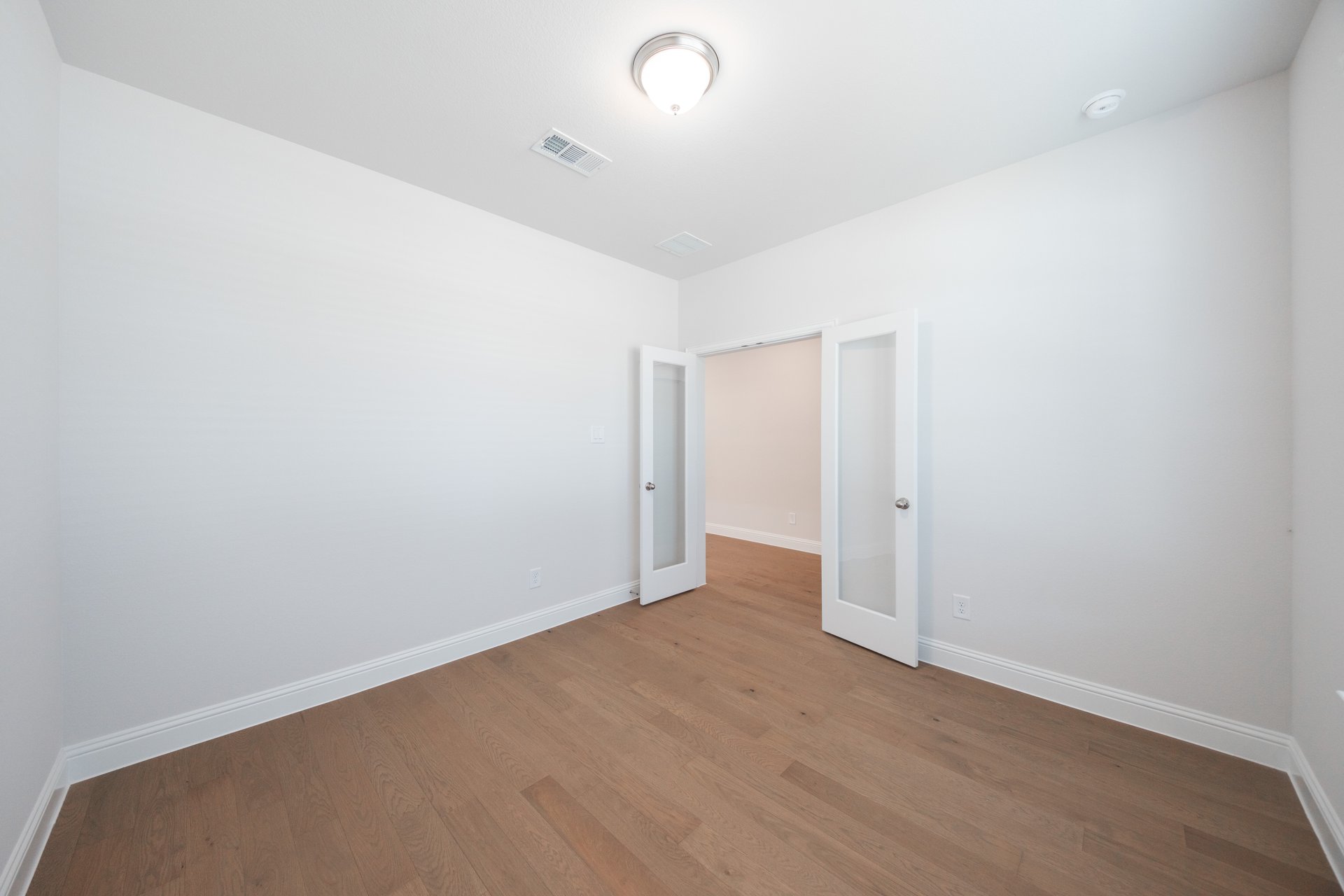 private study with wood floors and french doors