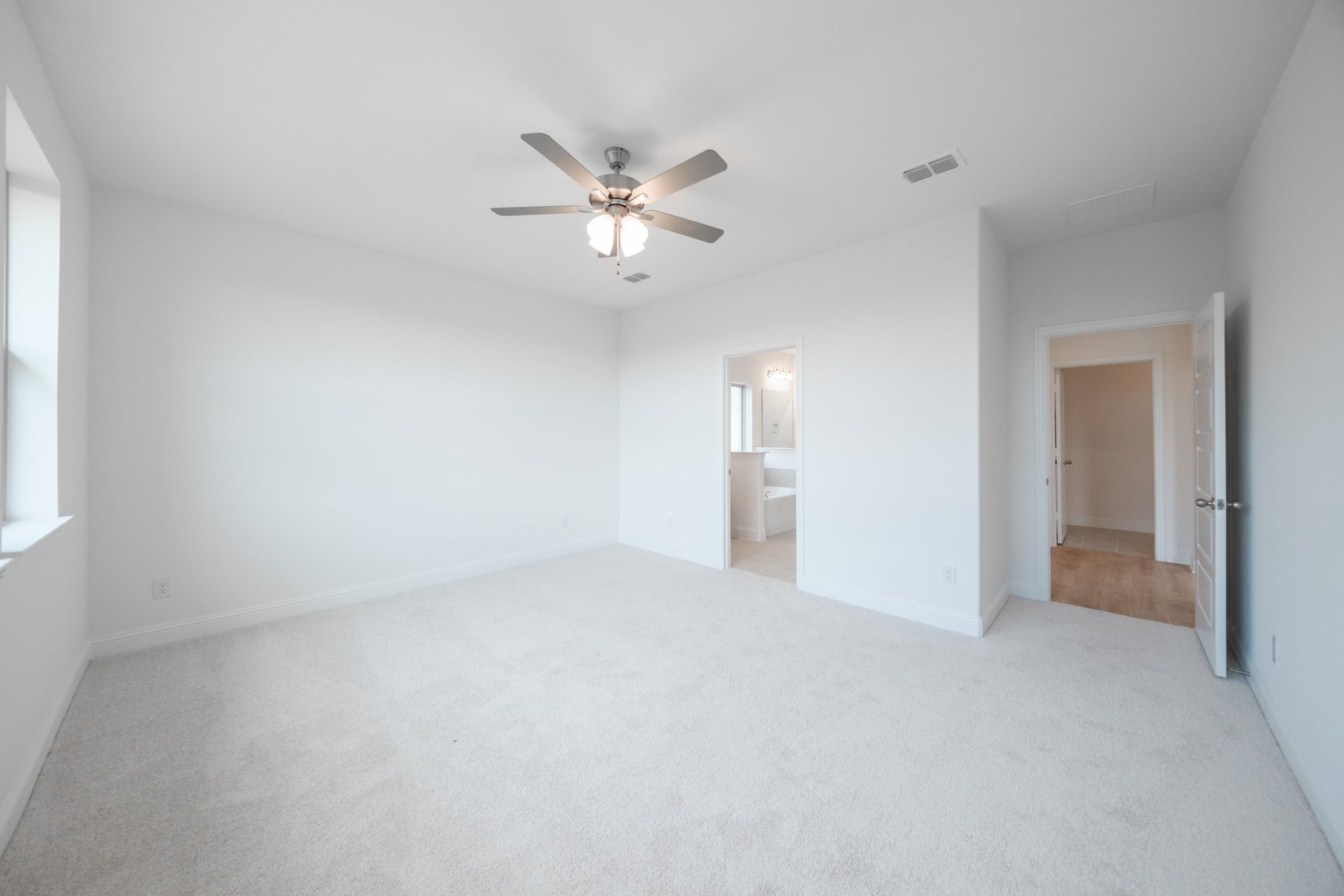 primary bedroom with carpet and ceiling fan