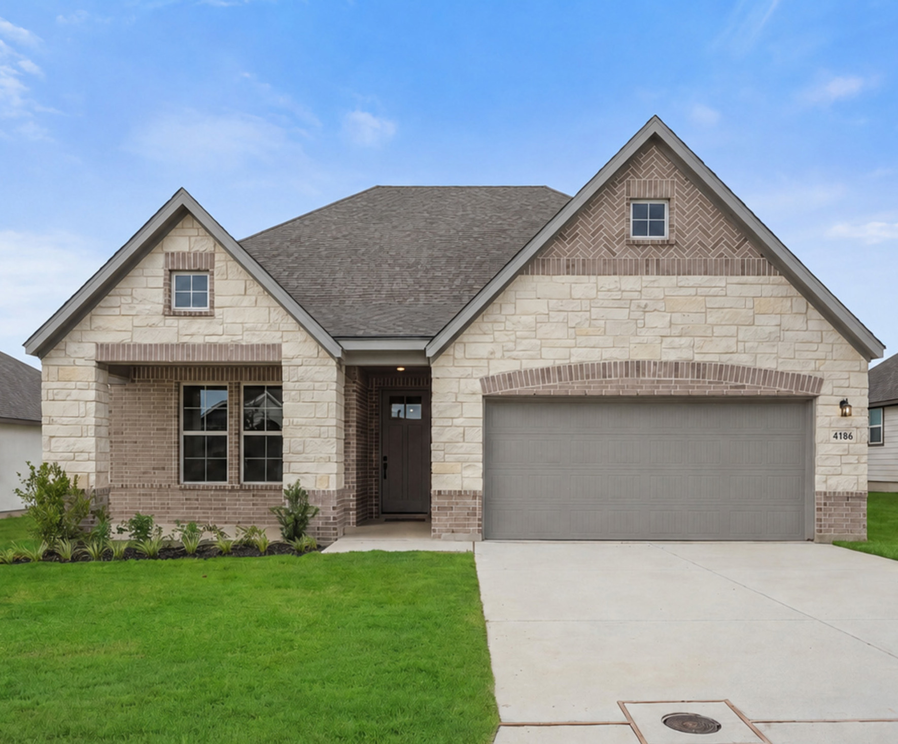 home with brick and windows and landscaped grass