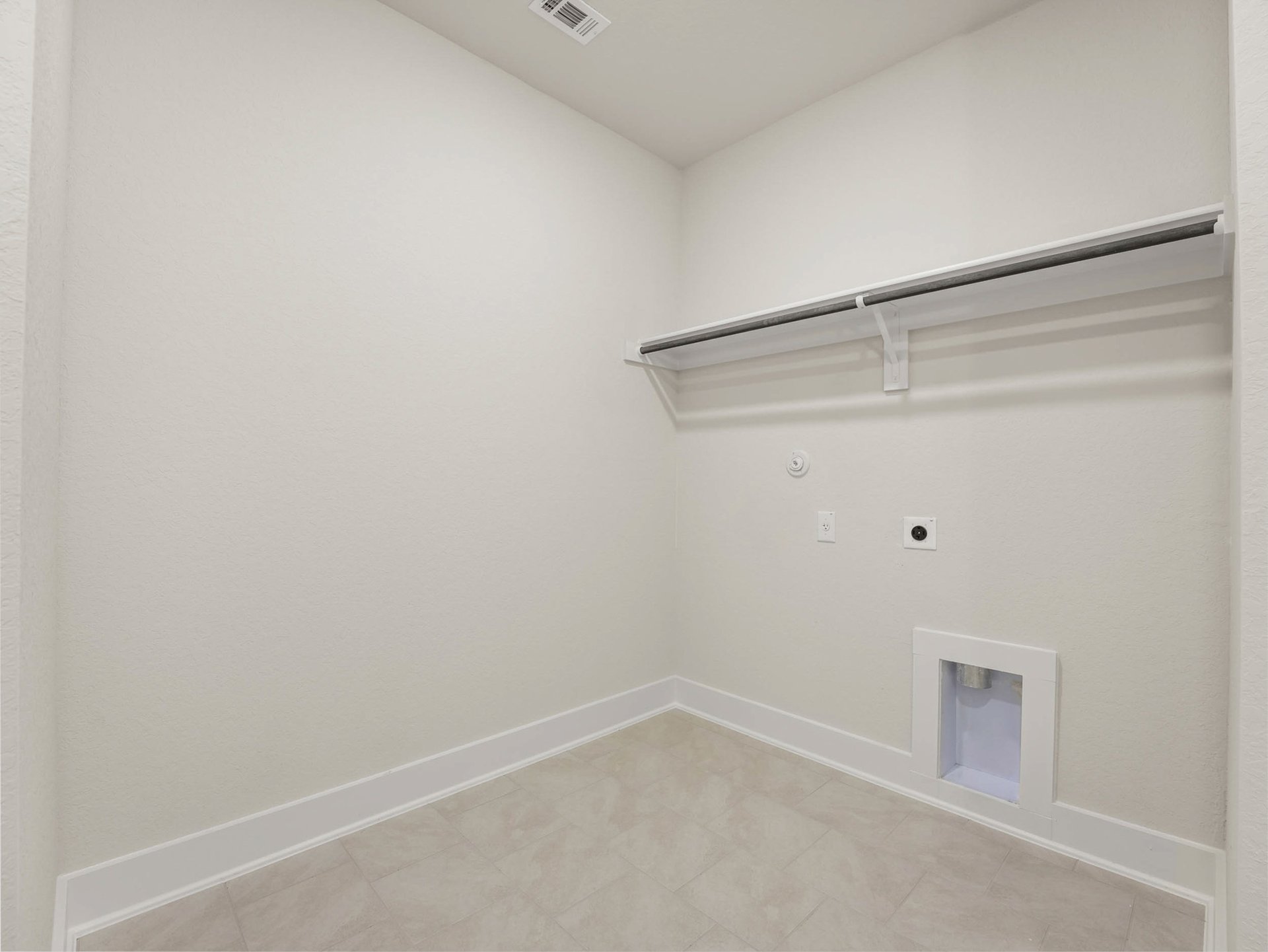 laundry room with beige flooring and white storage space