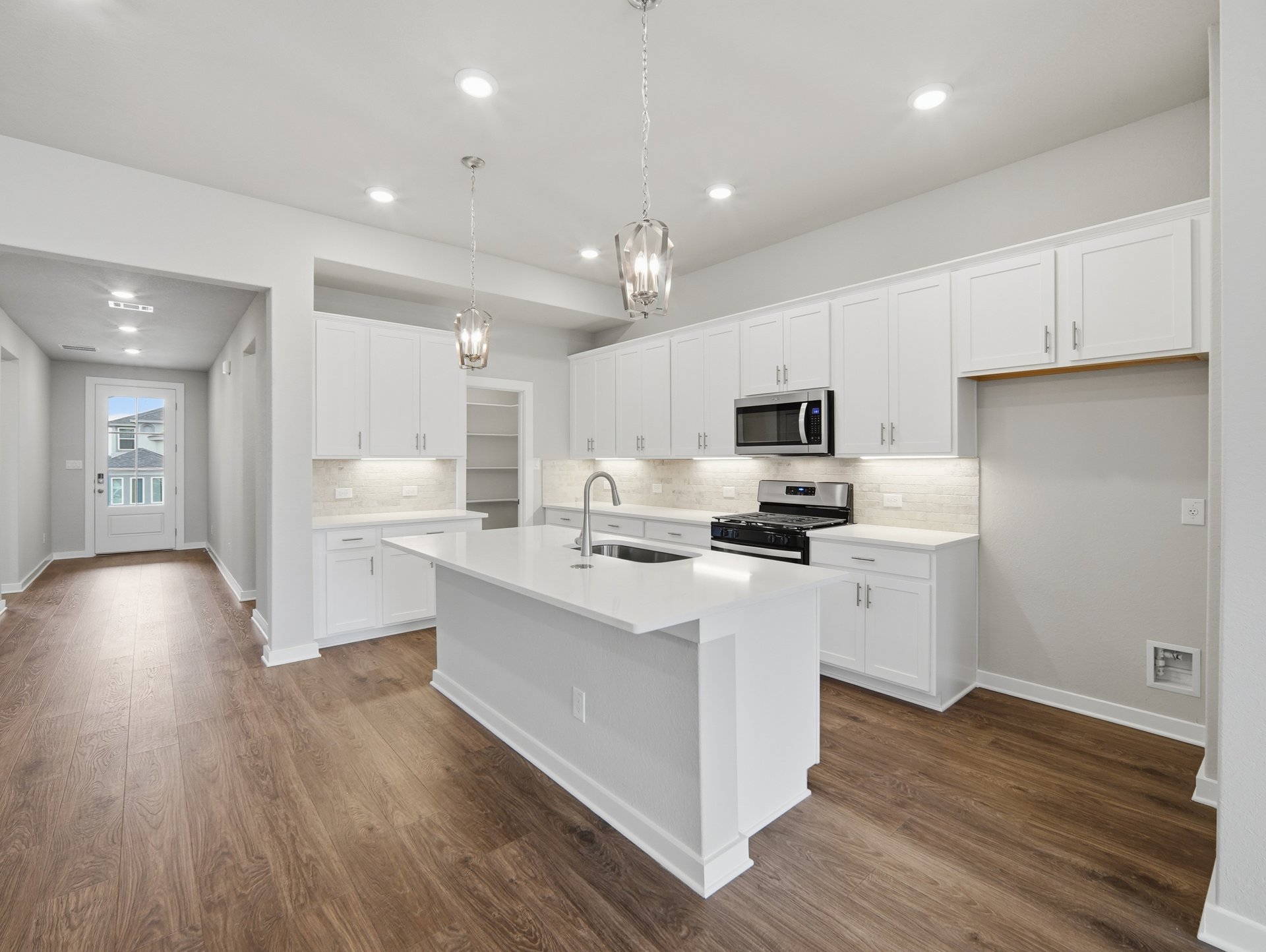 kitchen with quartz countertops, pendant lighting and white cabinents 