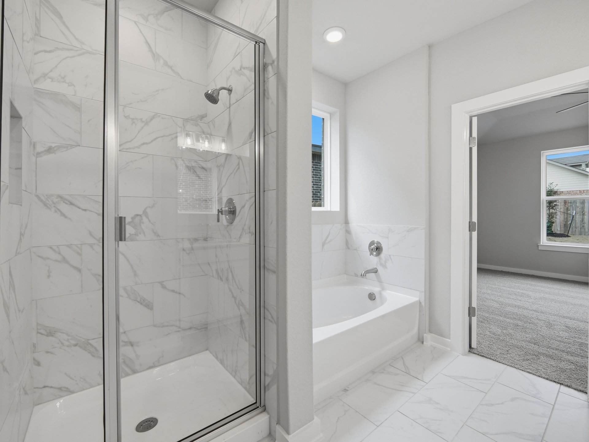 bathroom with walk-in shower and tub, window and tile flooring 