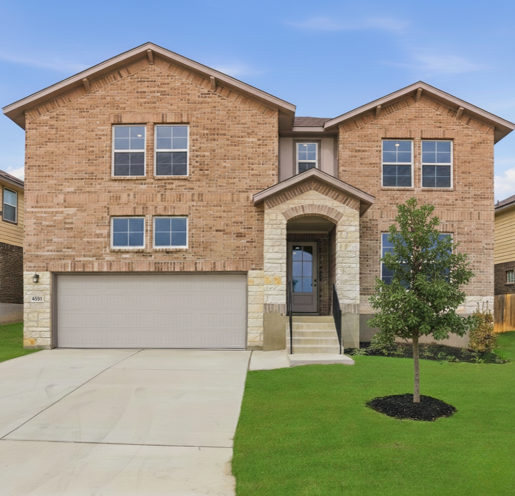 exterior with grass, tree and 2-car garage