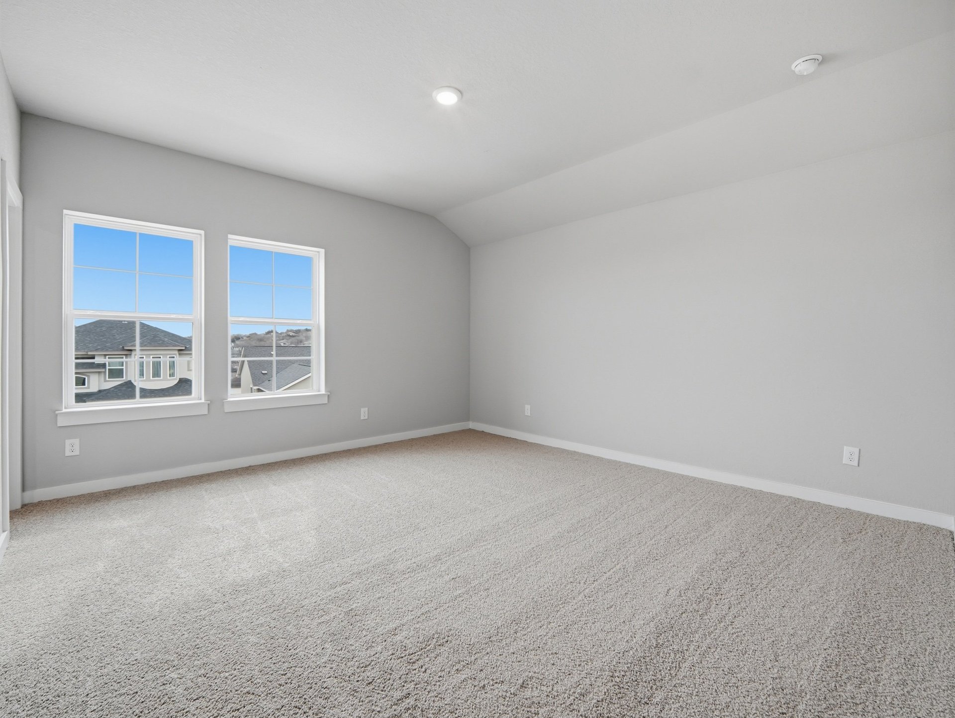 bedroom with carpet, windows and a sloped ceiling 