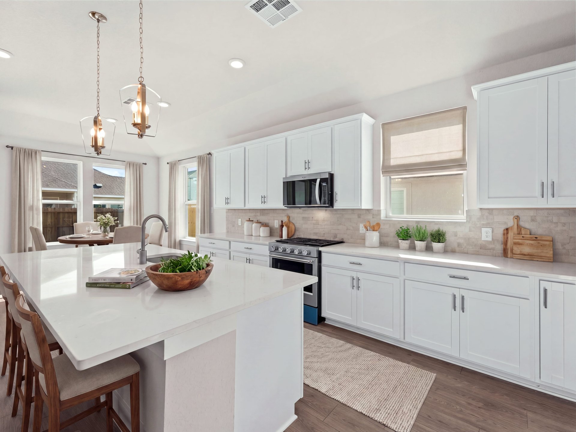 Kitchen with quartz countertops, pendant lighting and white cabinets