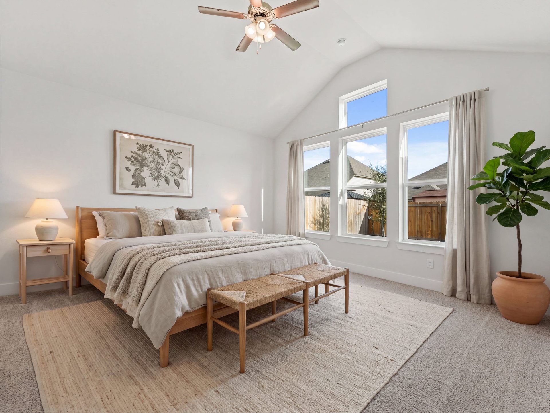 primary bedroom with carpet, windows, ceiling fan and a sloped ceiling