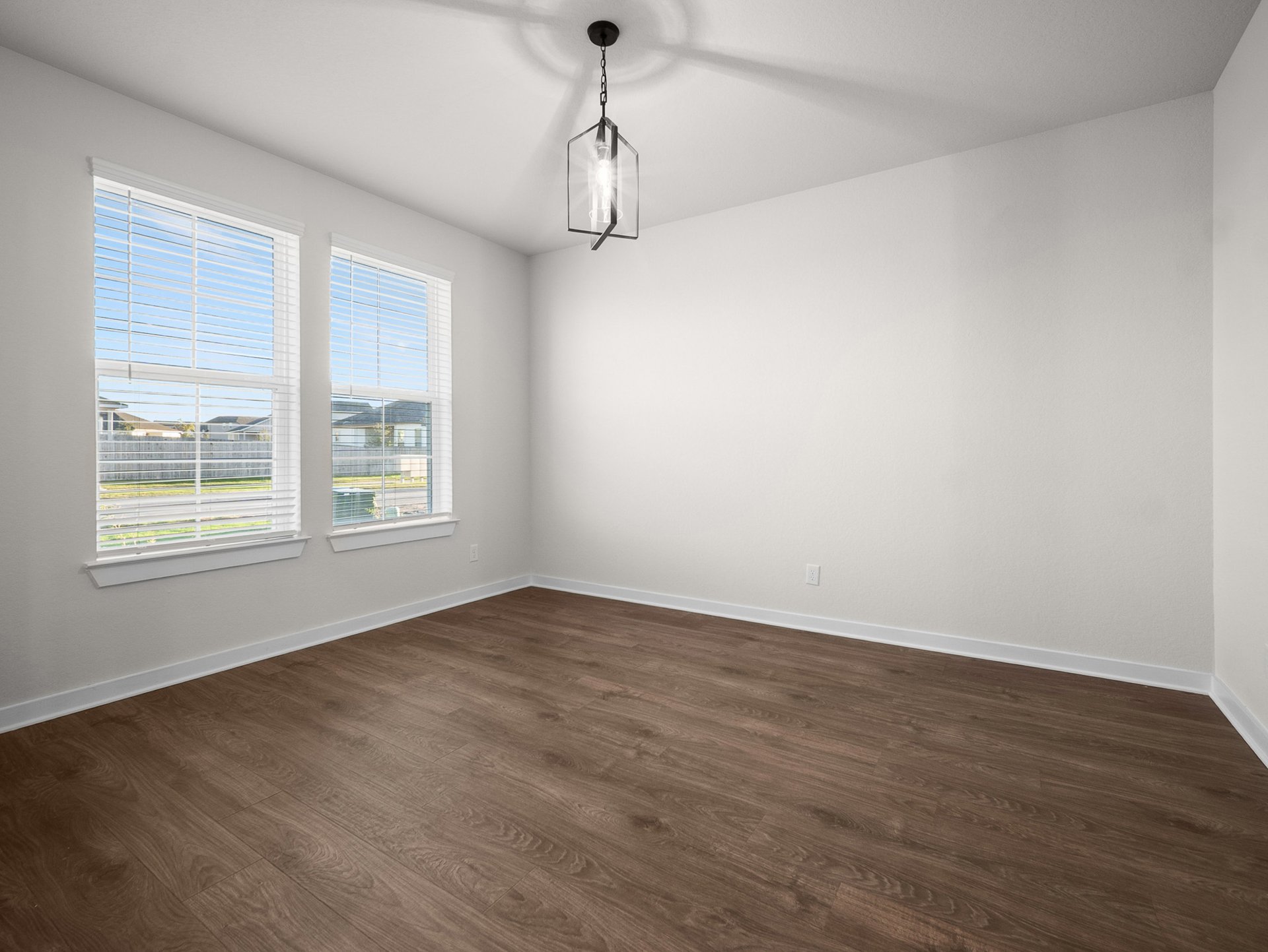 study with brown flooring, windows & a sloped ceiling