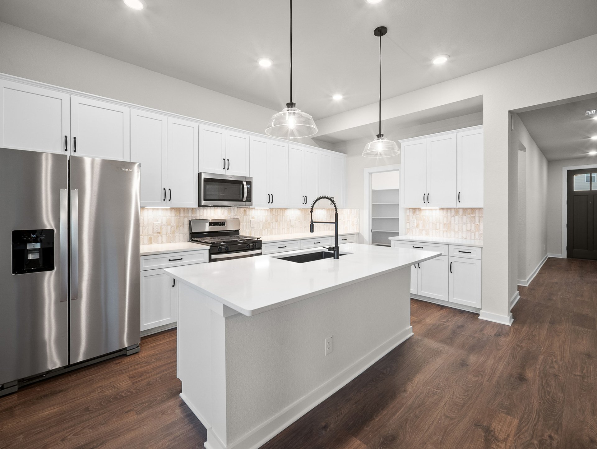 kitchen with quartz countertops, pendant lighting & white cabinets