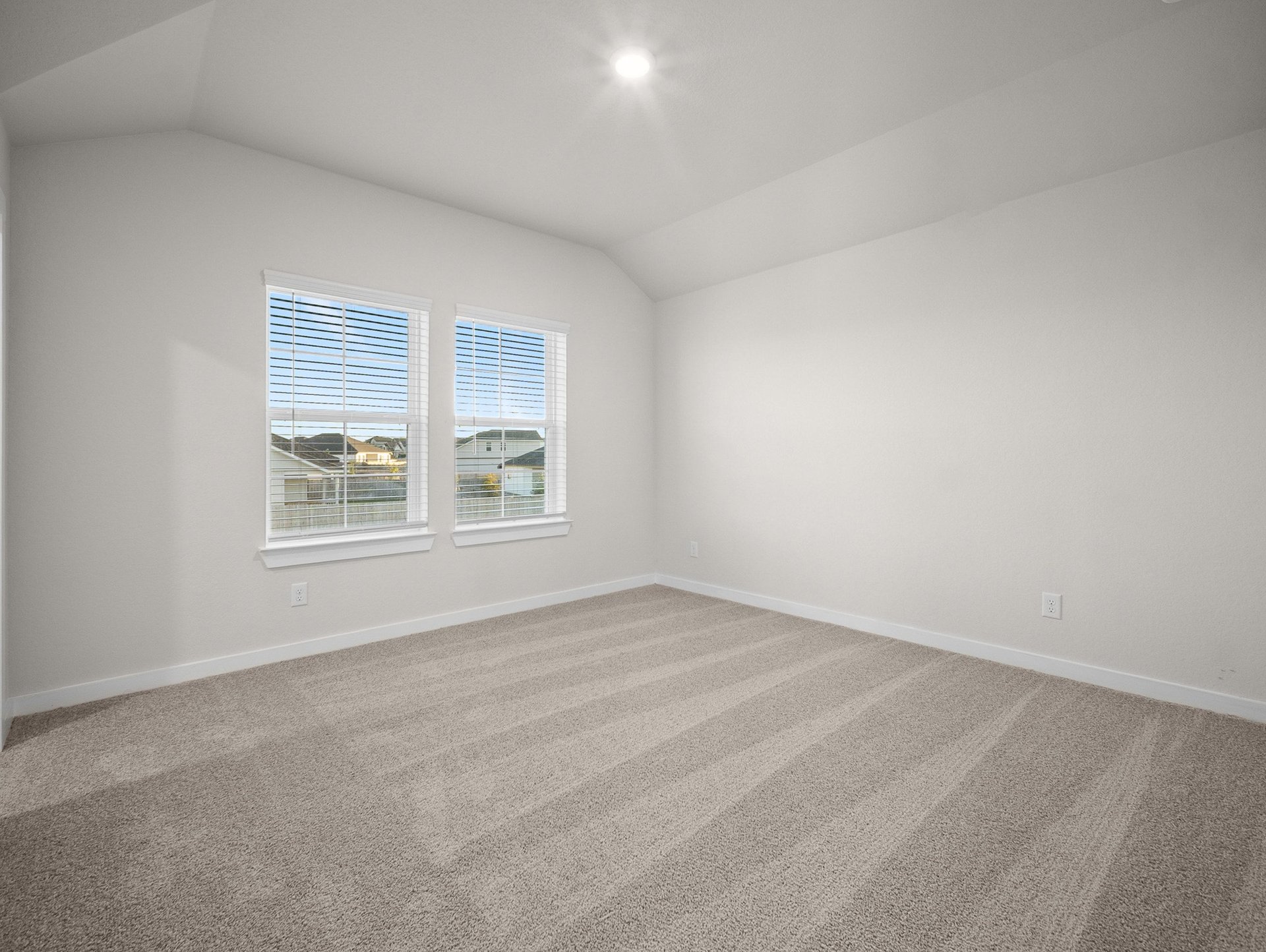 bedroom with carpet, windows & a sloped ceiling
