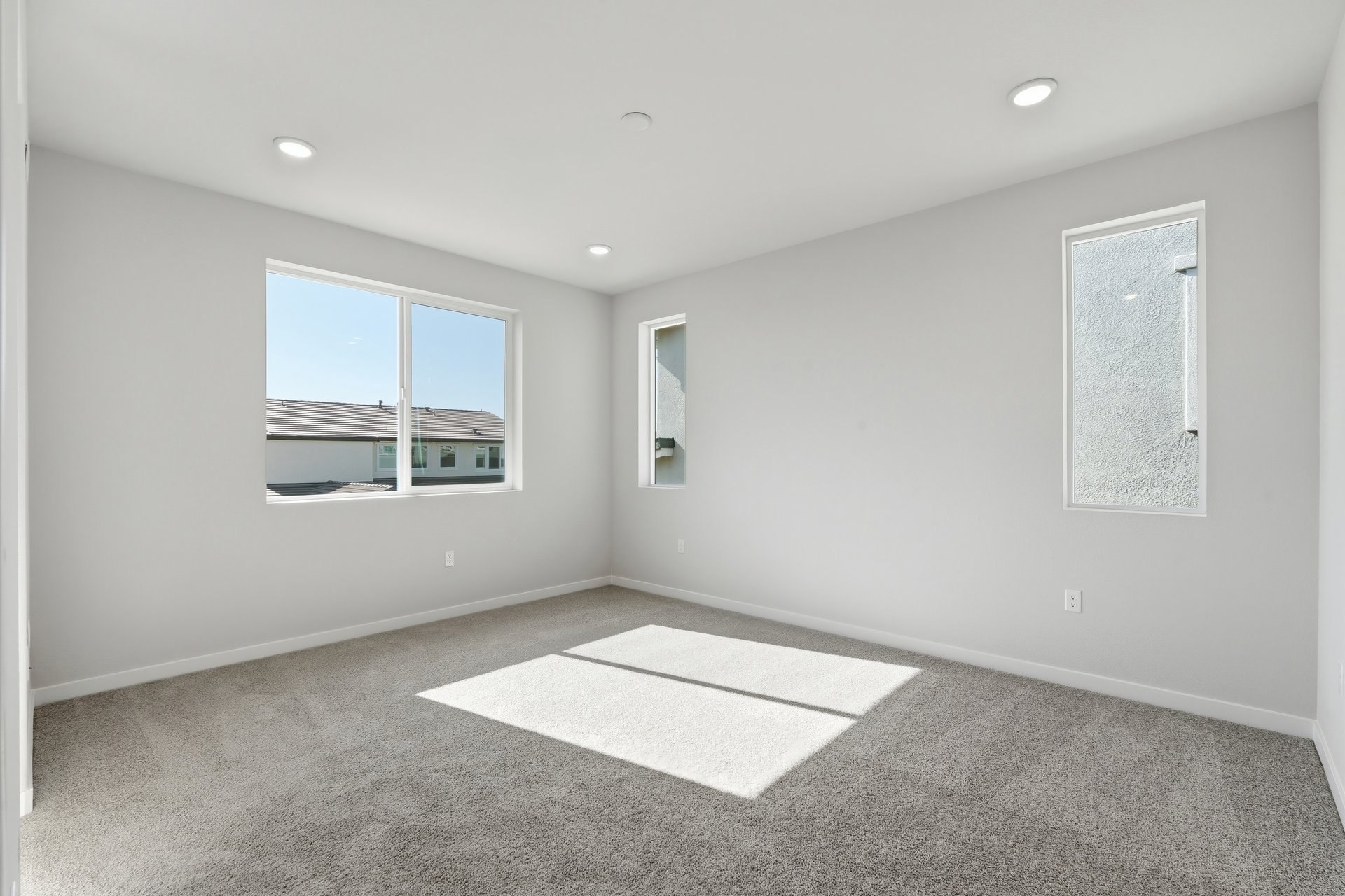 bedroom with gray carpet, white walls, multiple windows, and recessed ceiling lights