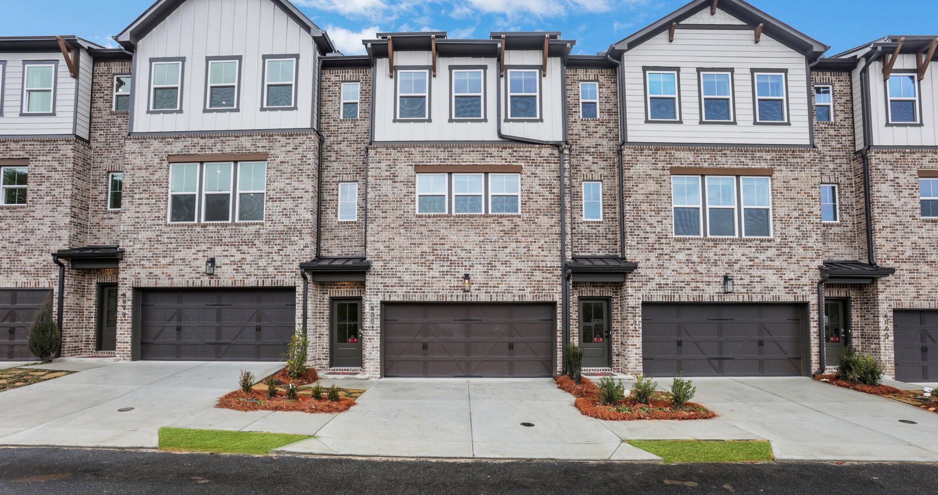 front of 3-story townhome with brick and wood details