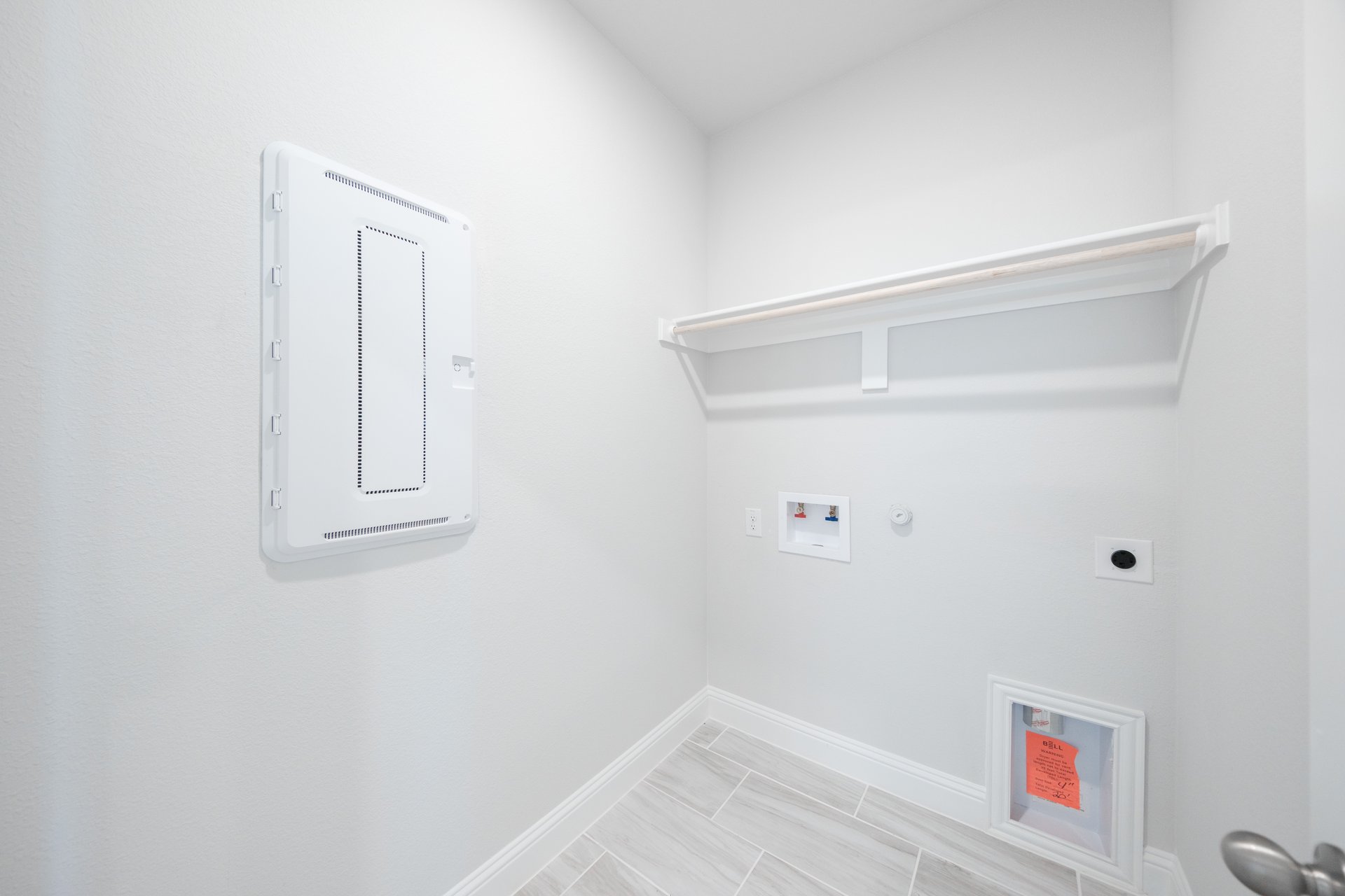 laundry room with tile floors and white shelf