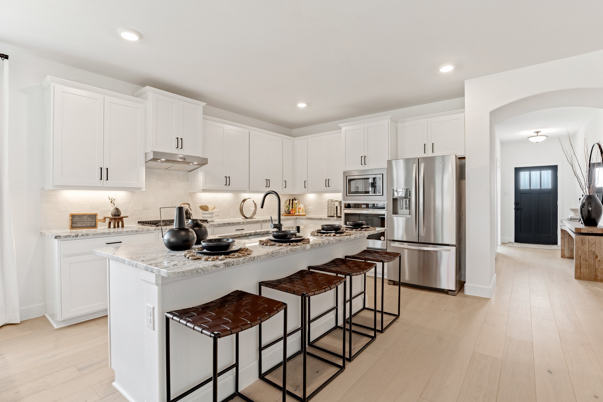 open kitchen with wood floors and white cabinets