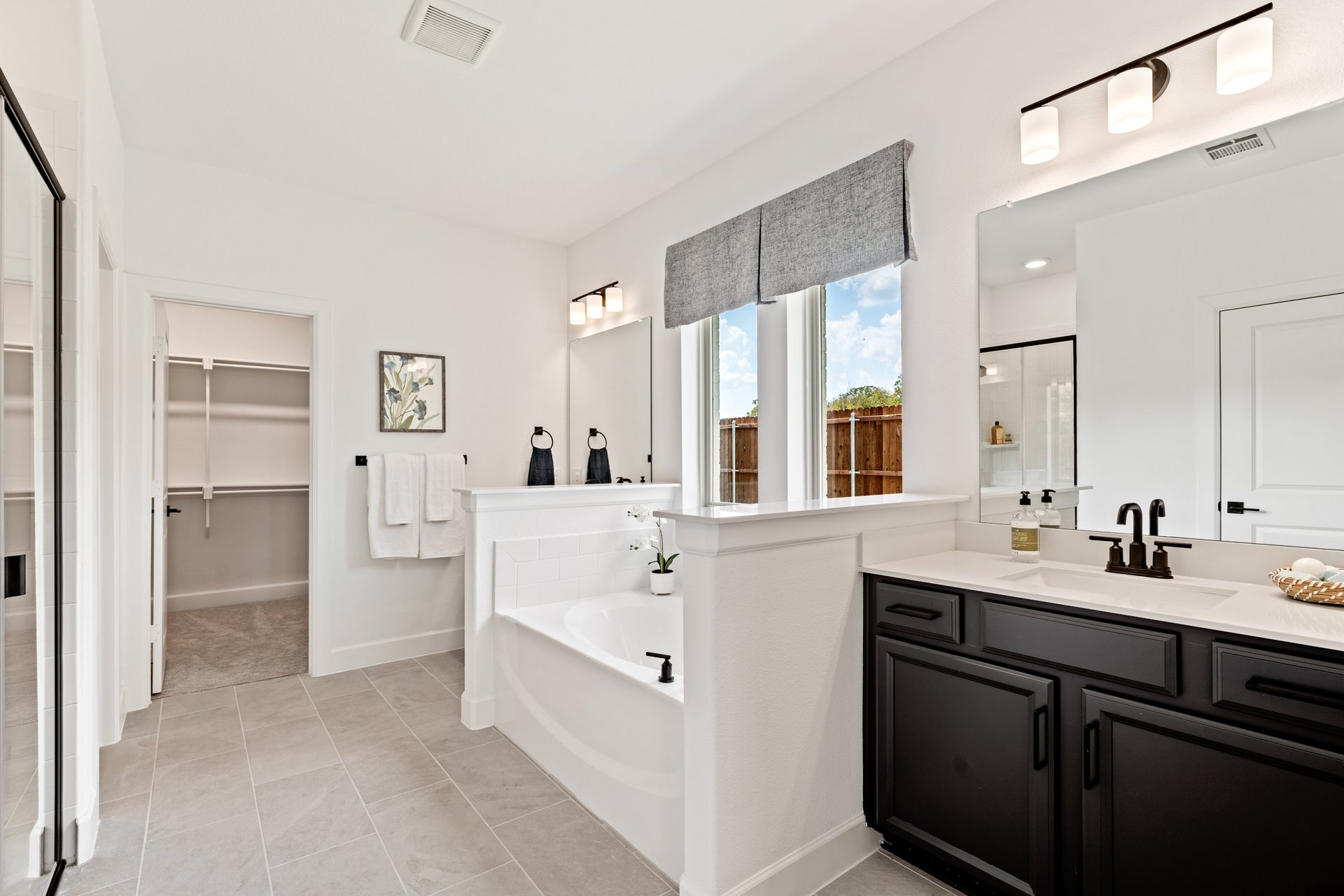 primary bathroom with soaking tub and tile floors 